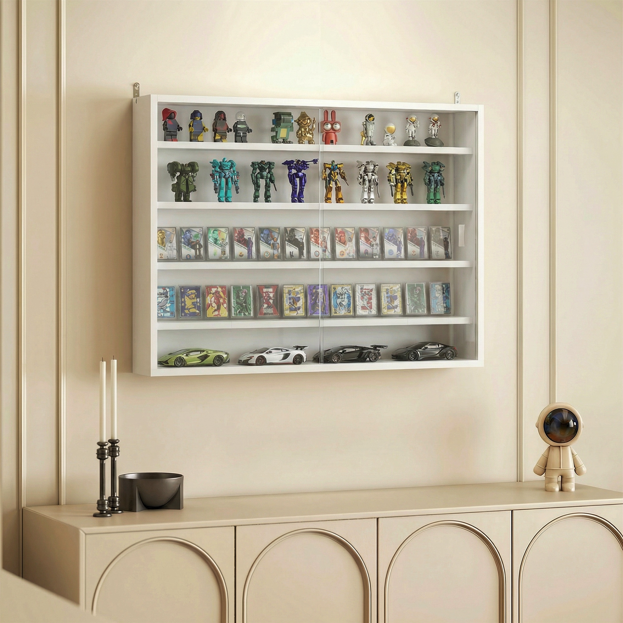Estante blanco con figuras, cartas y coches sobre un mueble con una figurita.