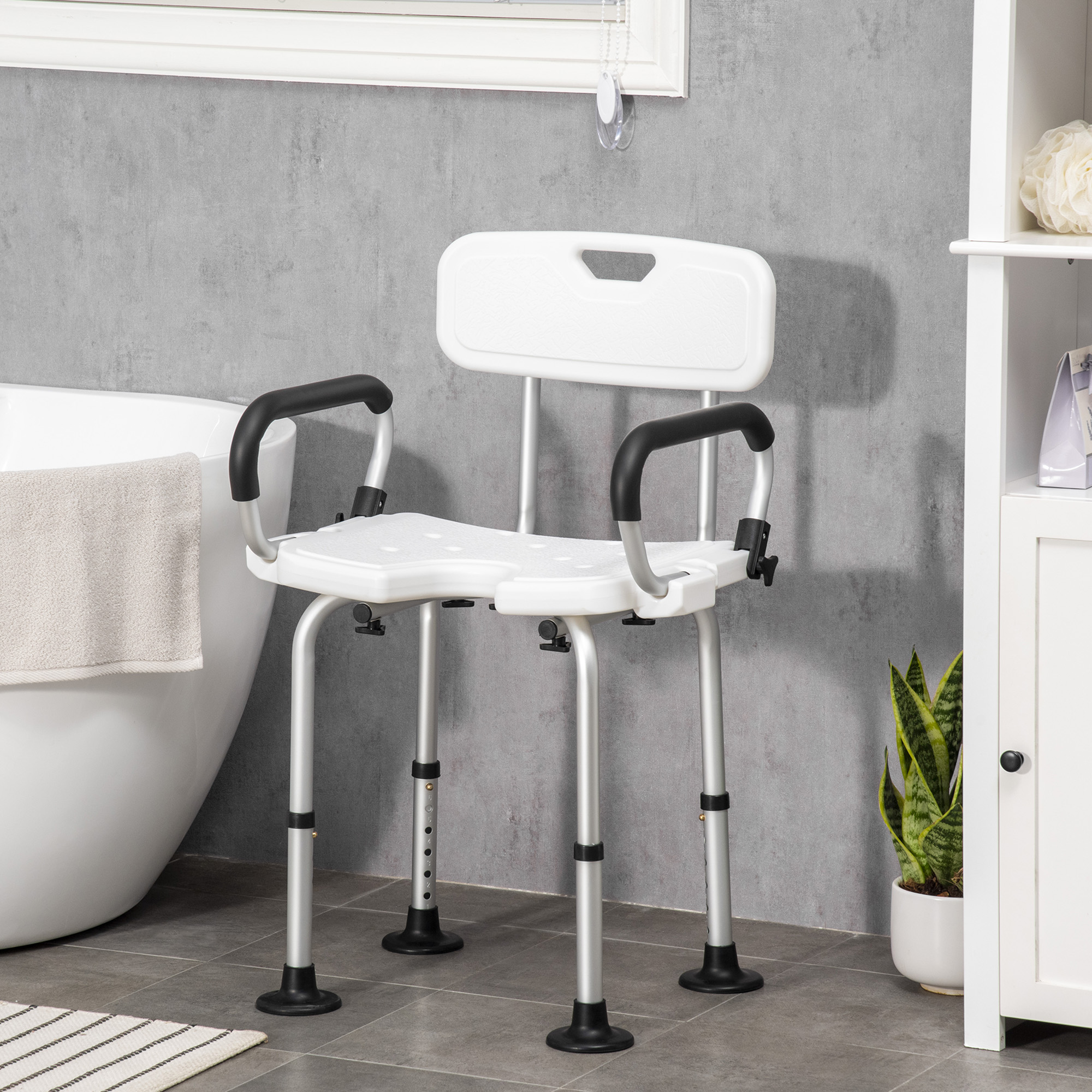 Una silla de ducha blanca con respaldo y reposabrazos está junto a una bañera.