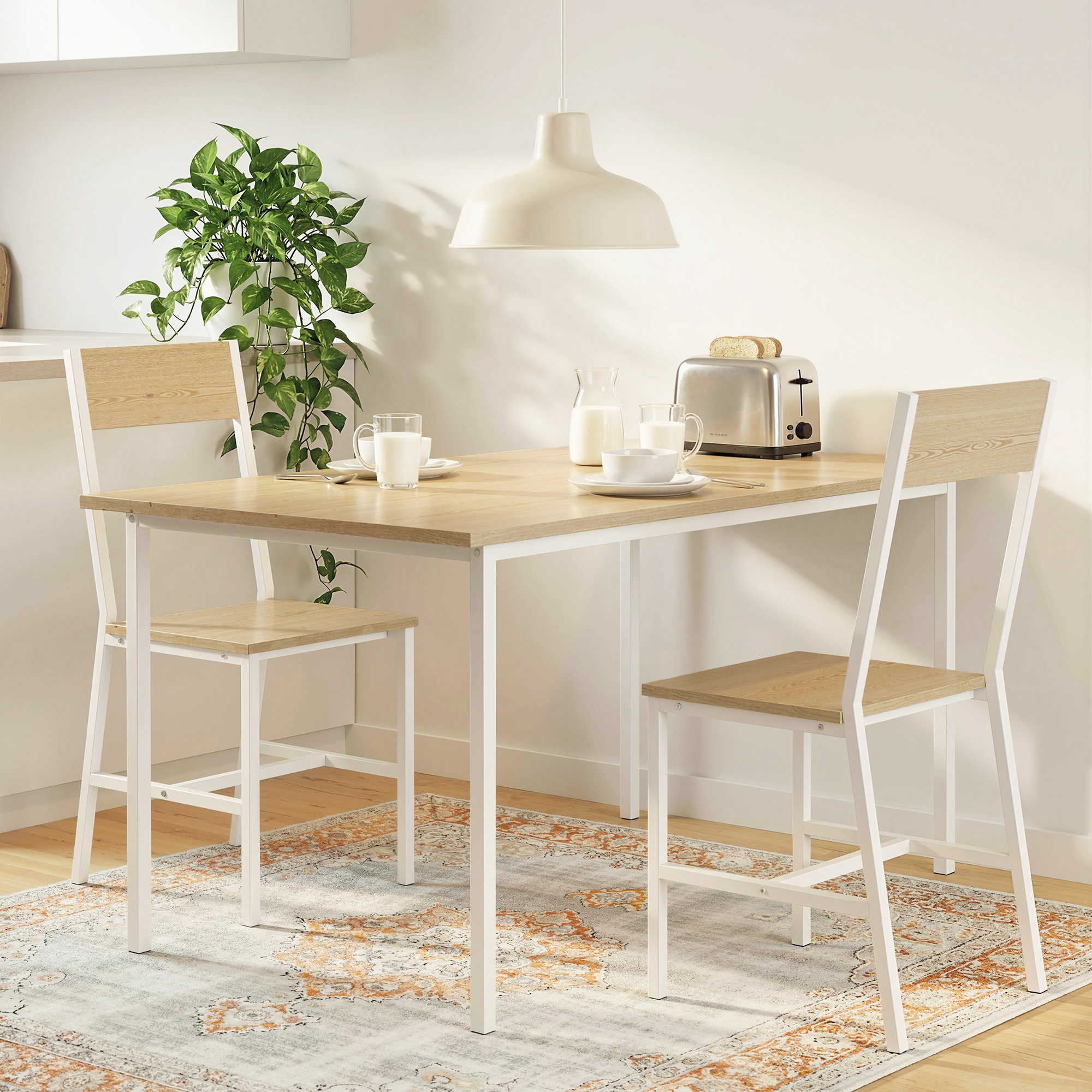 Una mesa de cocina luminosa con dos taburetes y artículos de desayuno.