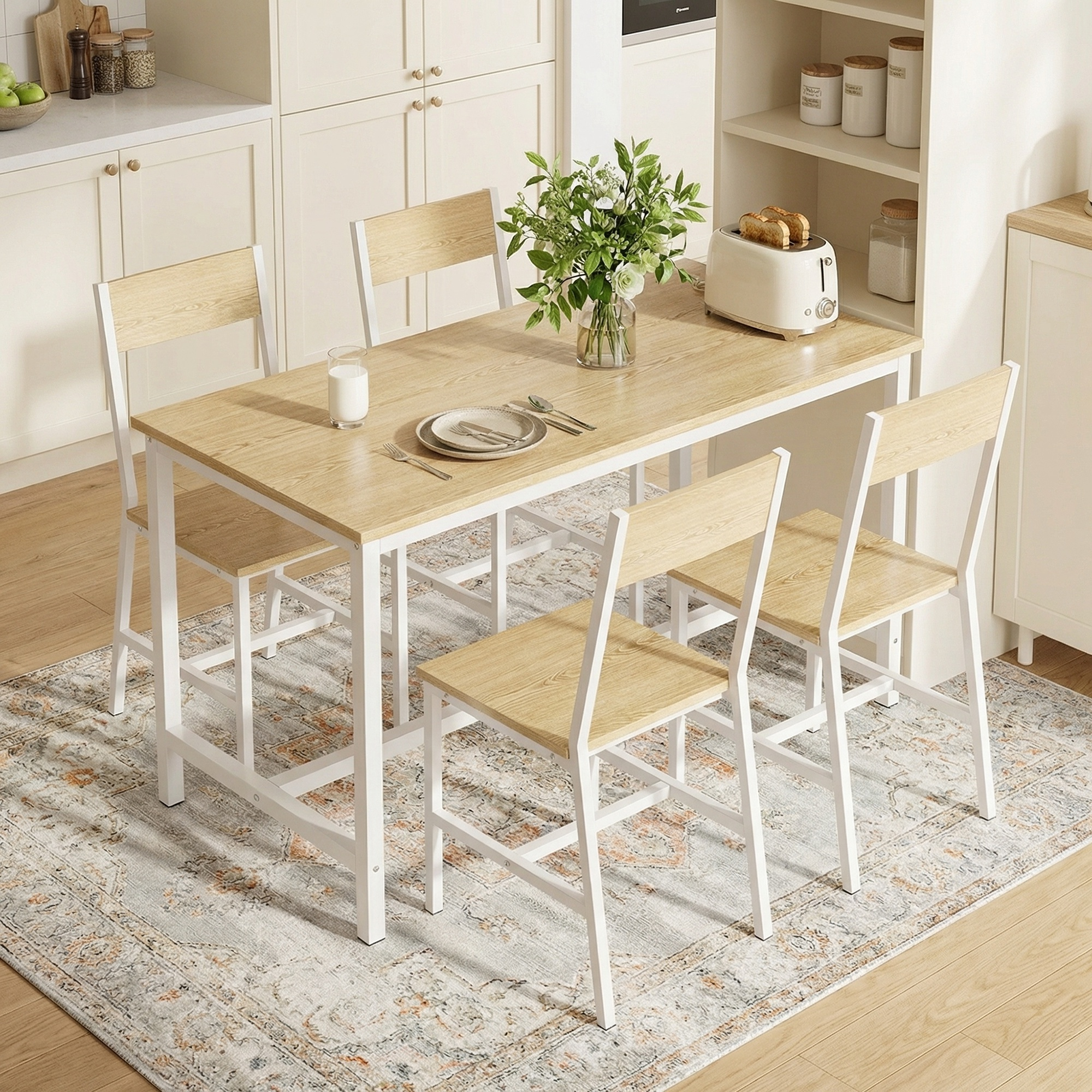 Una mesa de cocina con cuatro sillas, una tostadora y flores sobre una alfombra.
