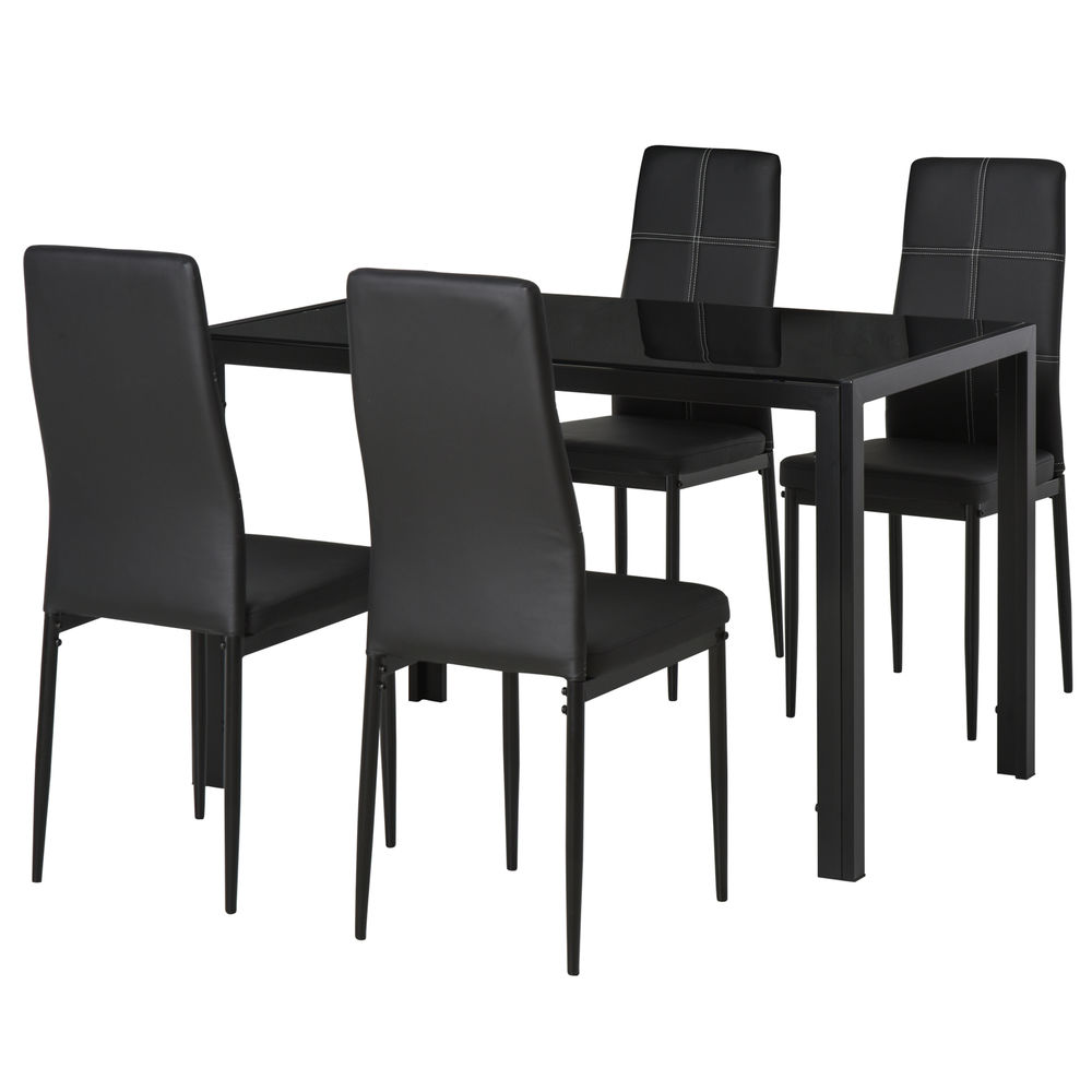Una mesa de comedor negra con cuatro sillas negras, pespuntes blancos, sobre fondo blanco.