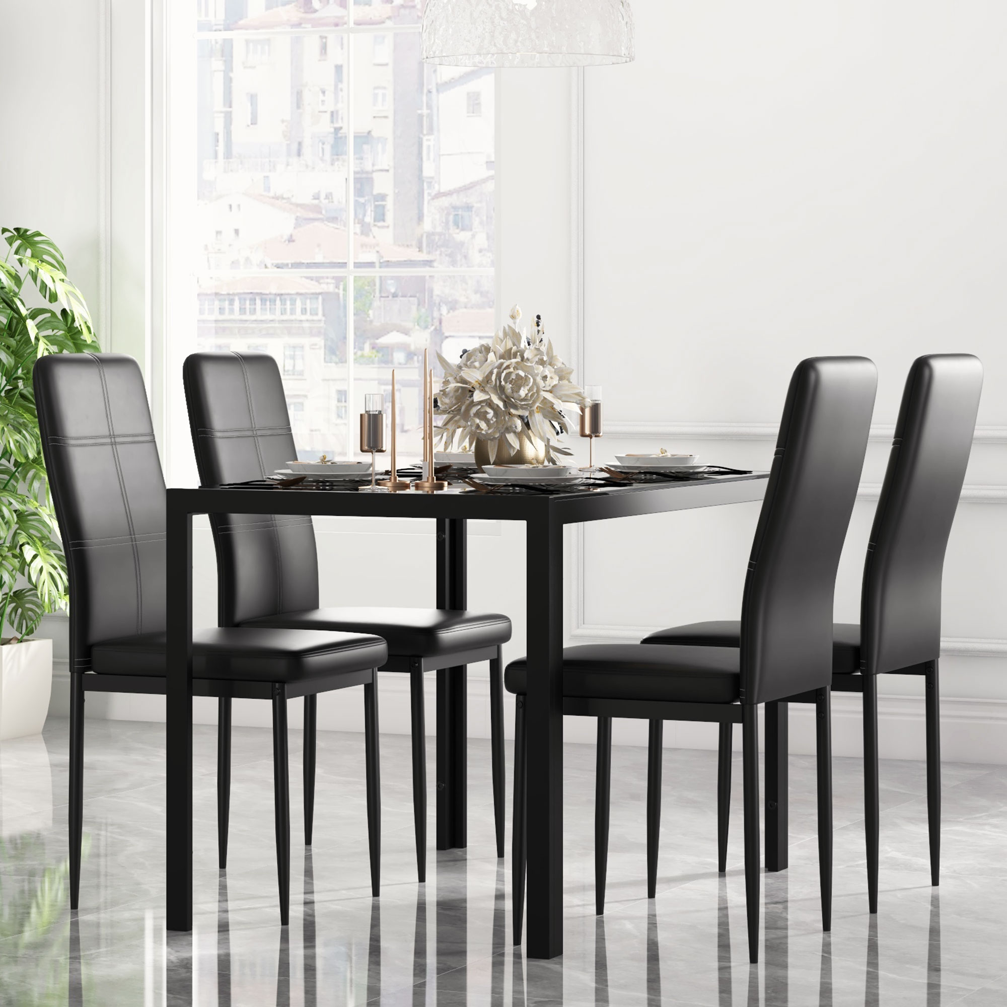 Mesa de comedor negra con cuatro sillas, puesta para una comida, con arreglo floral.