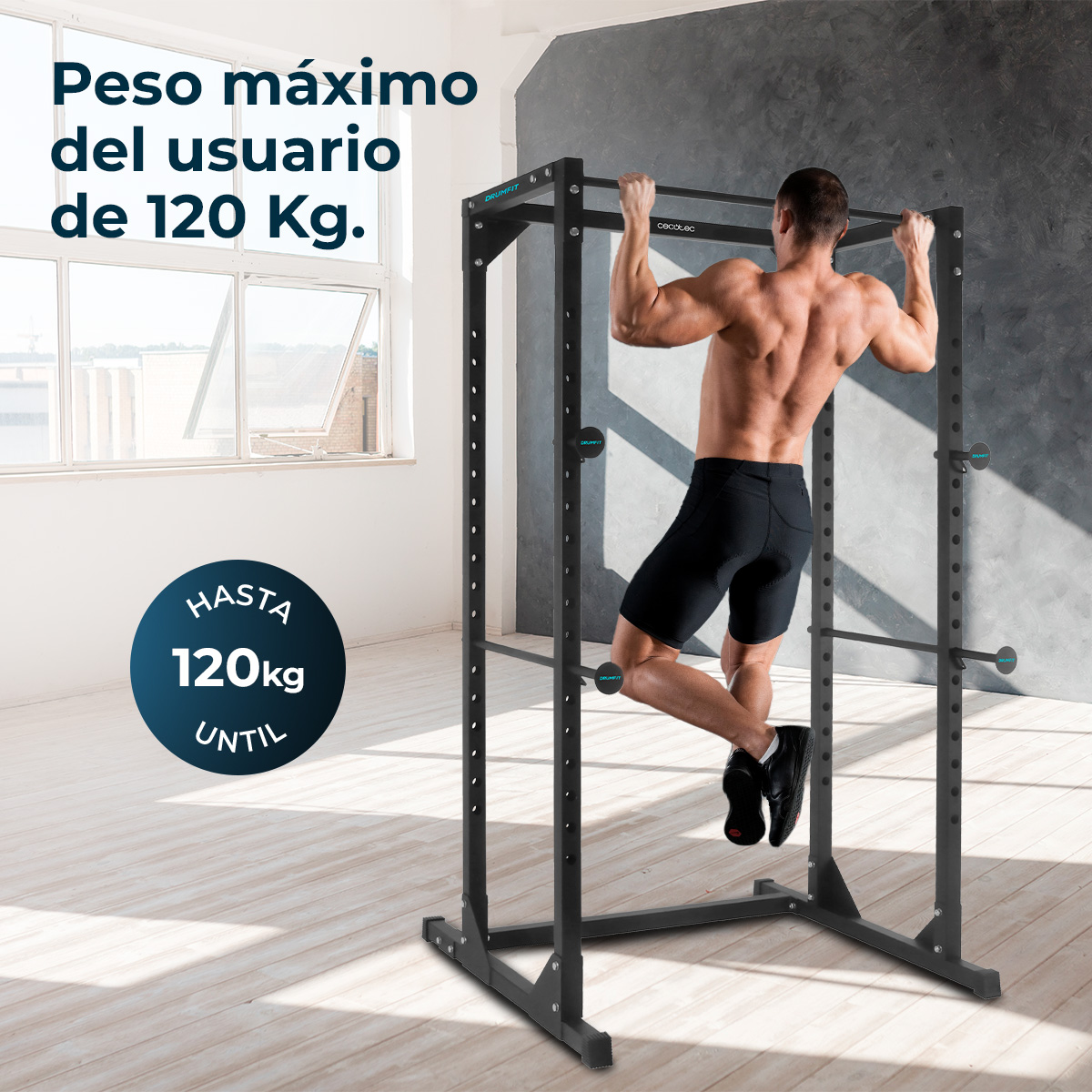 Hombre haciendo dominadas en una jaula de potencia negra. Máx. 120 kg.