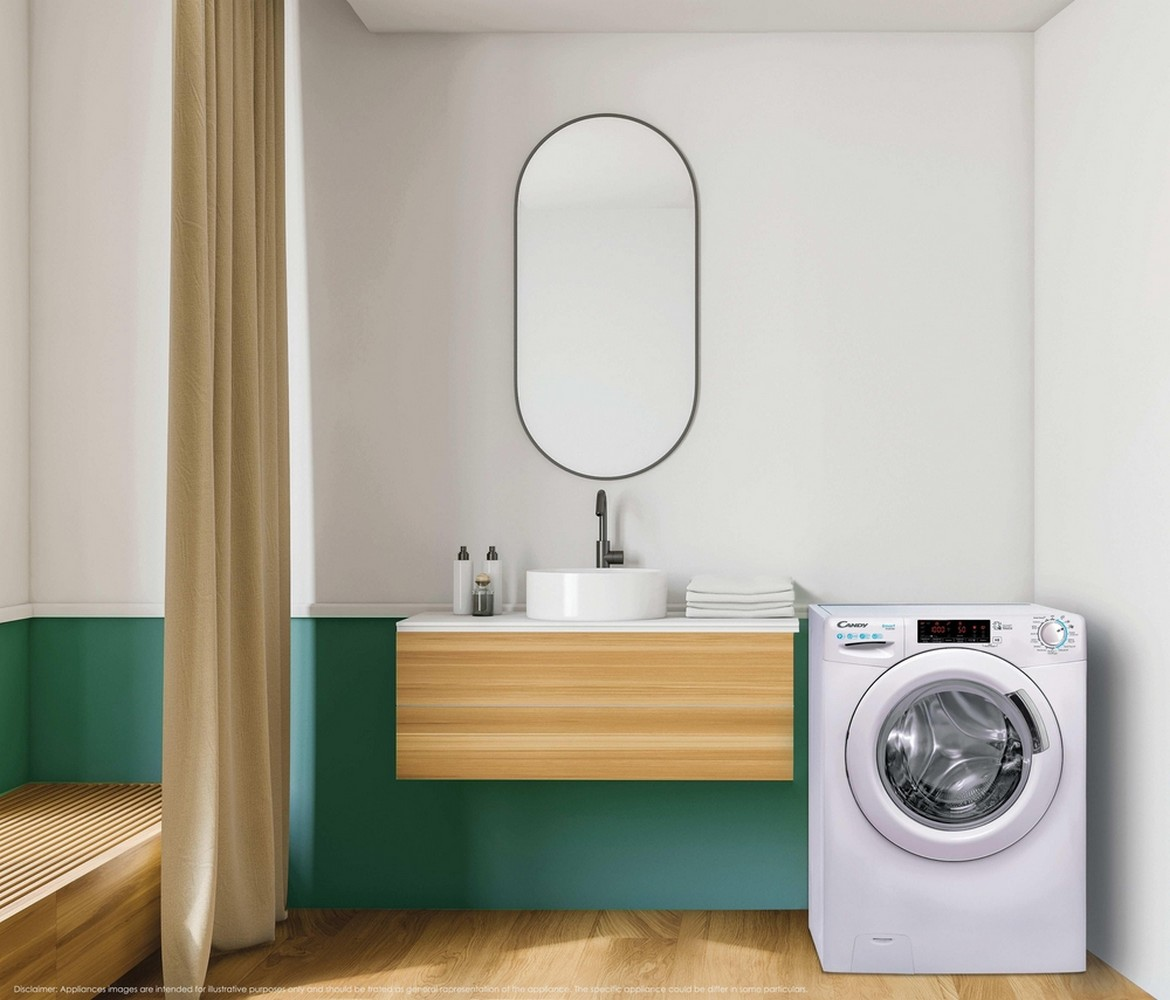 Una lavatrice bianca accanto a un mobile bagno in legno con lavandino e specchio.