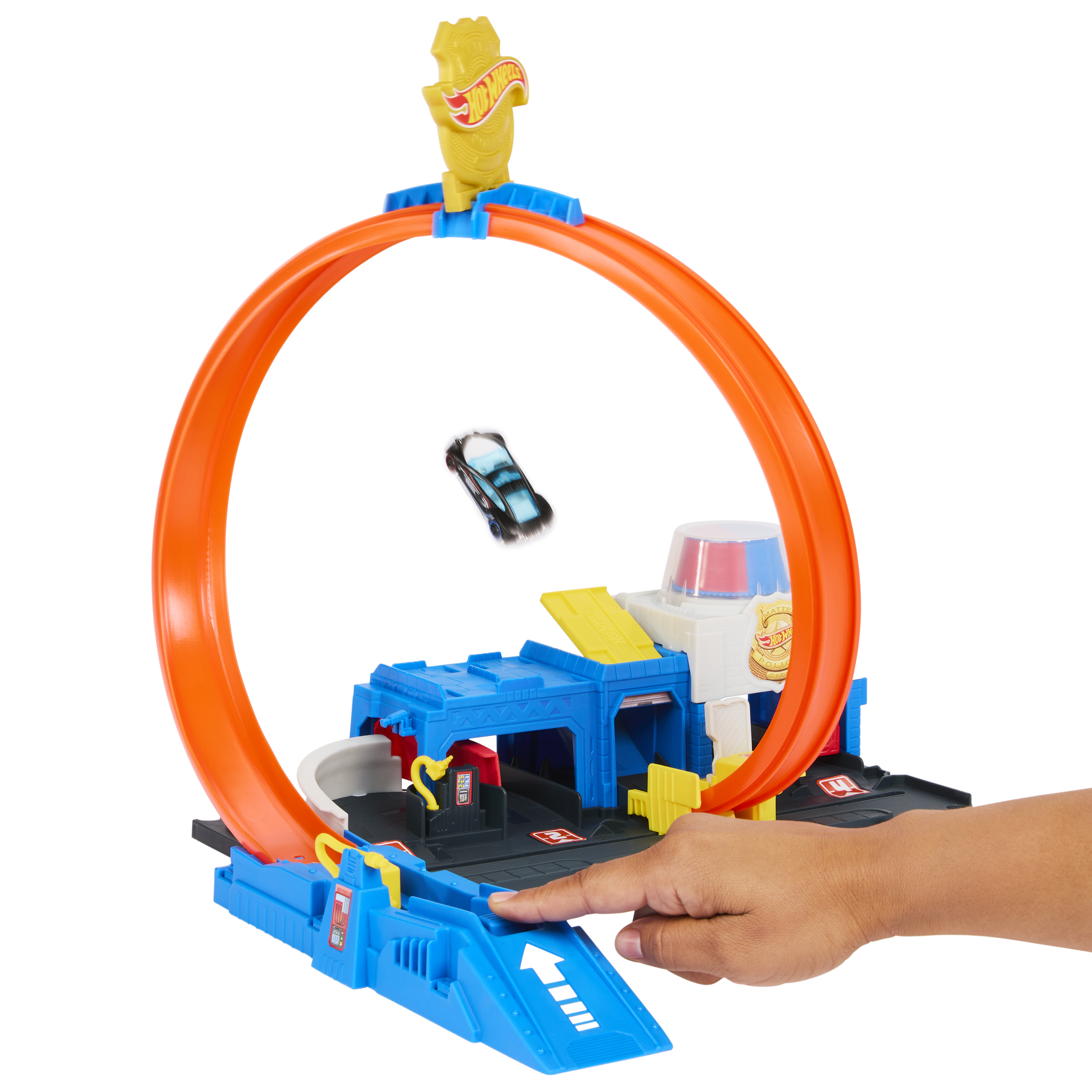 Un coche de juguete corre por un bucle naranja en un set de acrobacias de juguete azul.