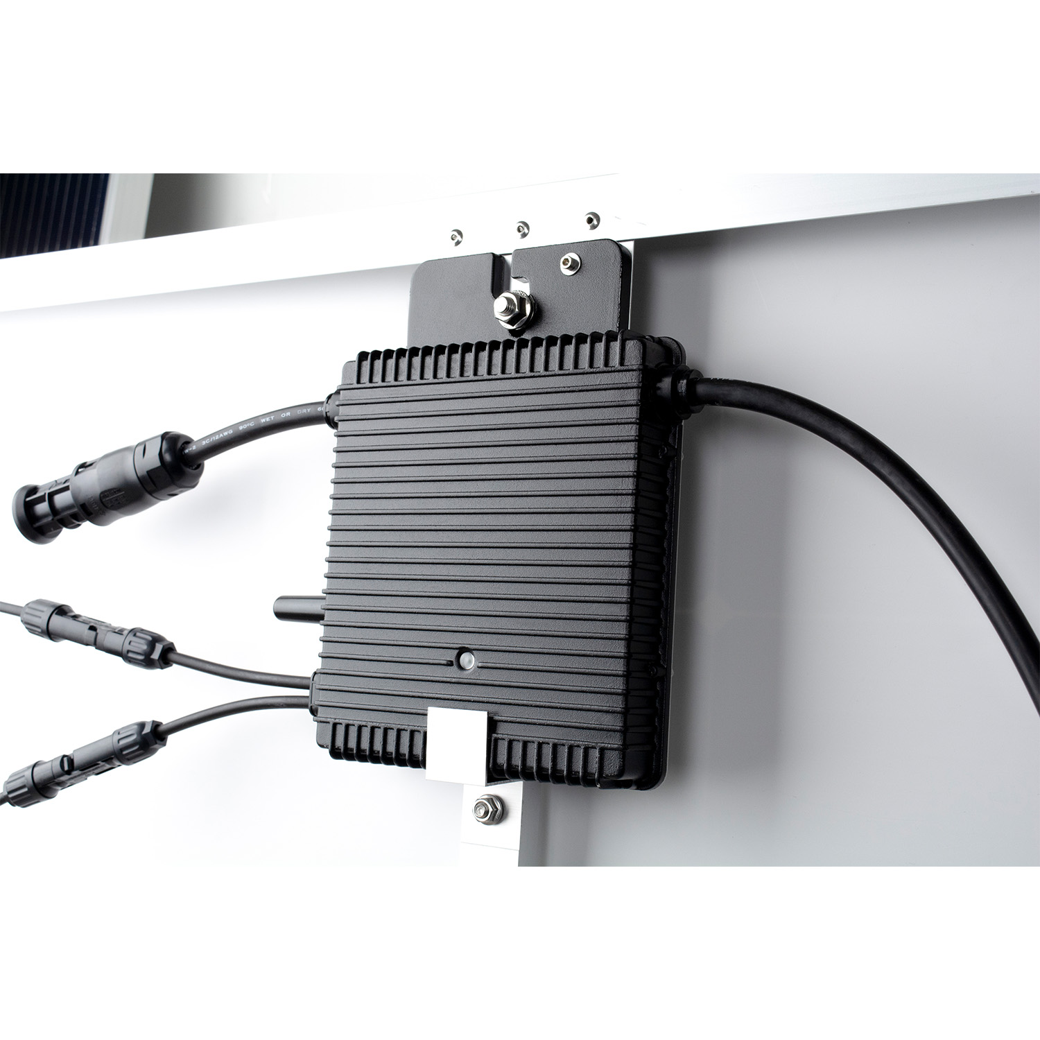 Un inverter nero e scanalato è montato su un pannello bianco con cavi collegati.