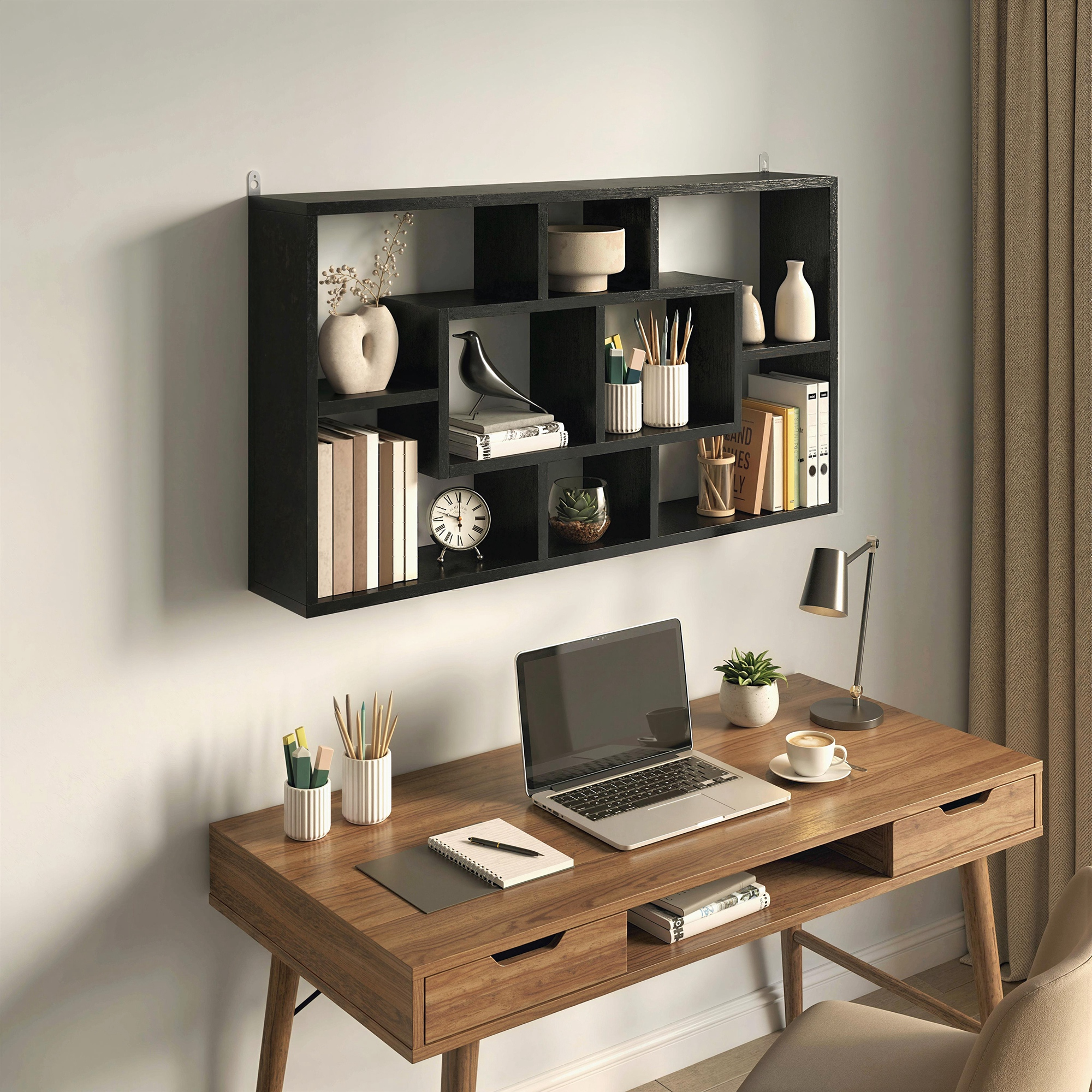 Estante de pared negro con libros, decoración y escritorio con portátil.