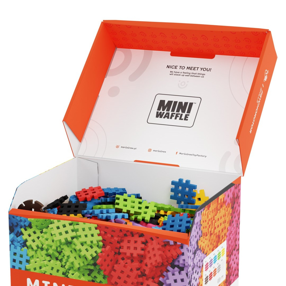 Caja abierta llena de bloques de construcción Mini Waffle coloridos en rojo, verde, azul y morado.
