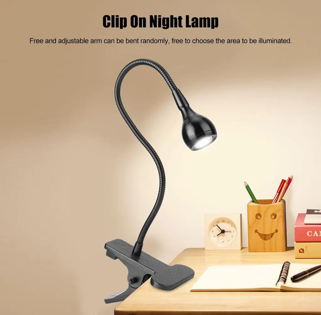 Eine schwarze Klemm-Nachttischlampe mit flexiblem Arm auf einem Schreibtisch.