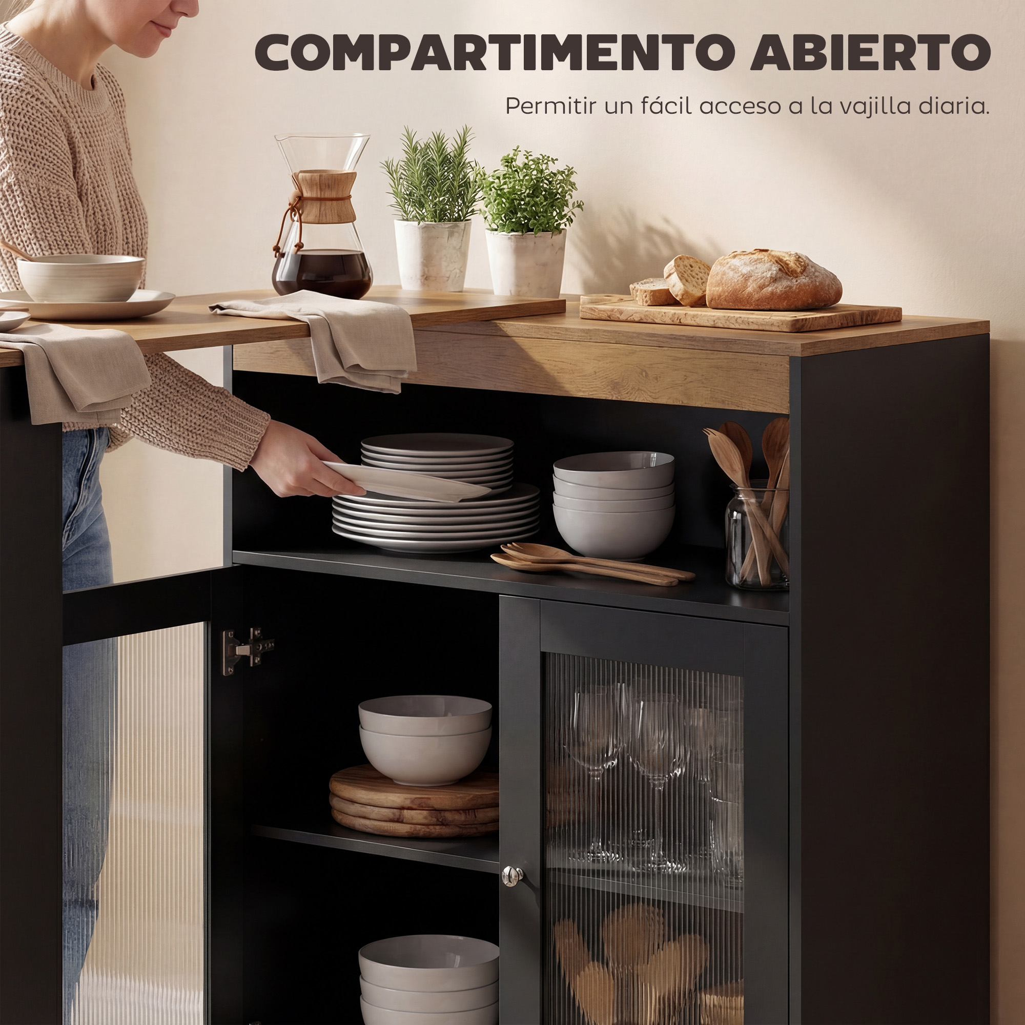 Una persona coloca platos en un armario oscuro con frente de cristal. Cafetera y pan arriba.