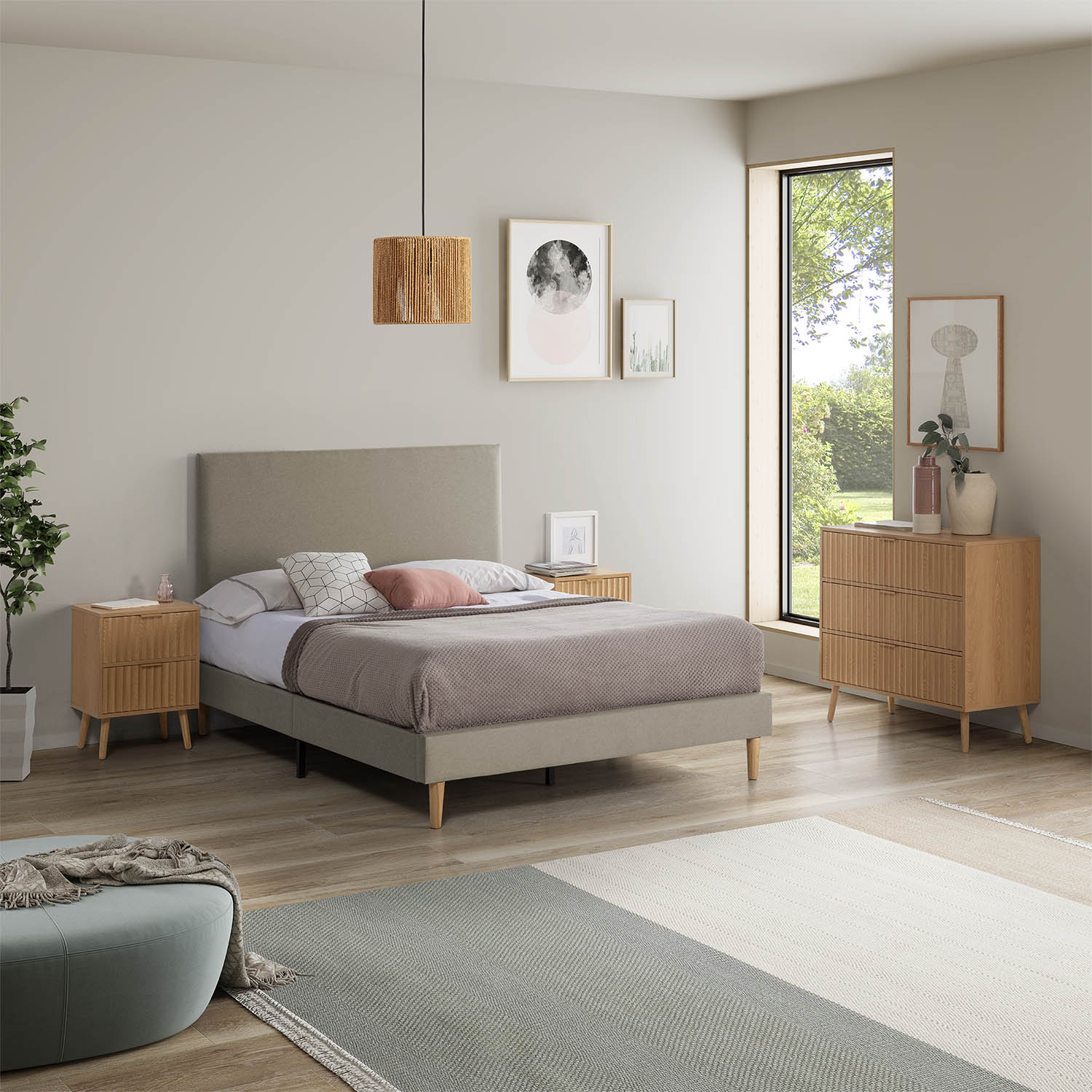 Un dormitorio con cama, mesitas de noche, cómoda y ventana con vistas a la vegetación.