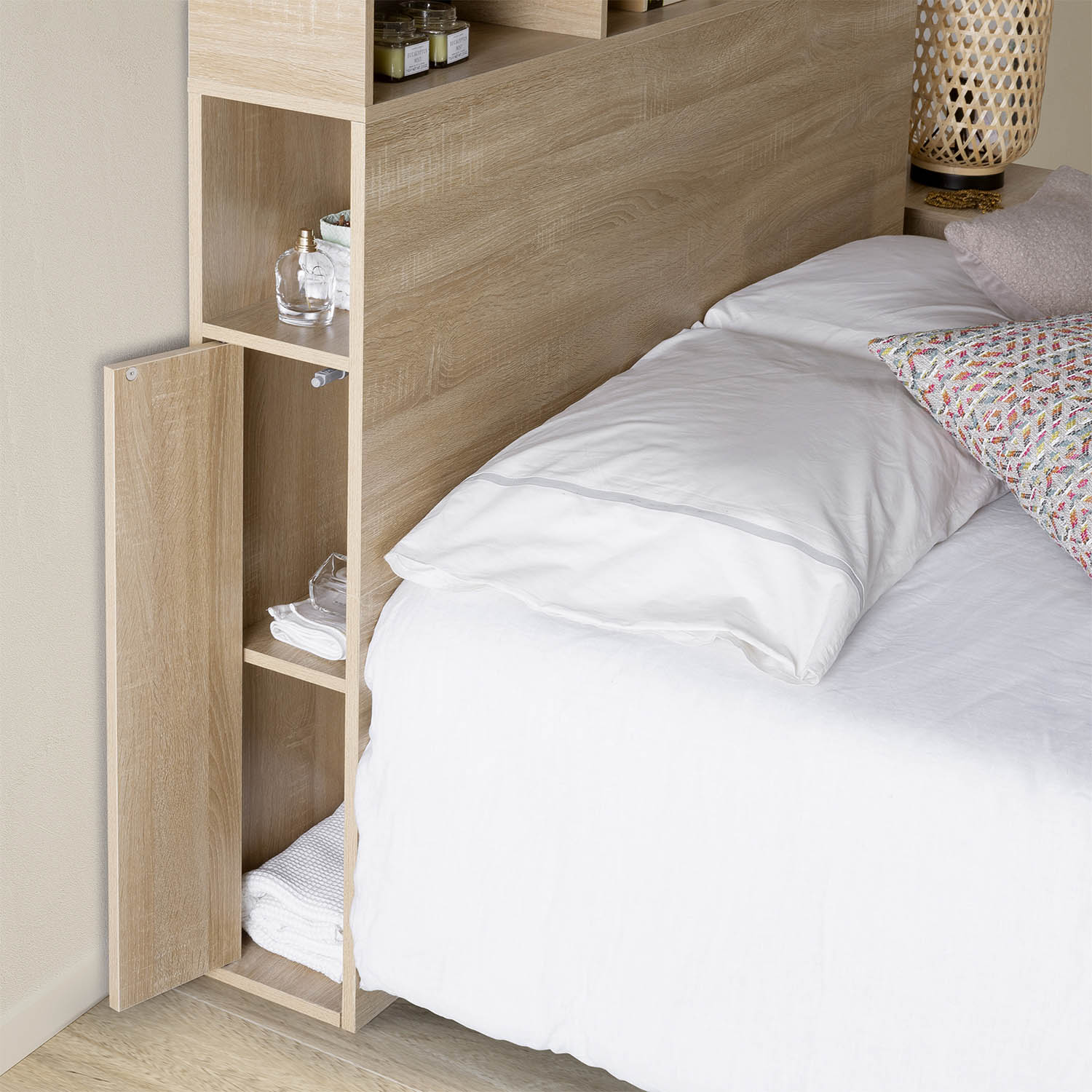 Una cama con sábanas blancas y un cabecero de madera con estantes.