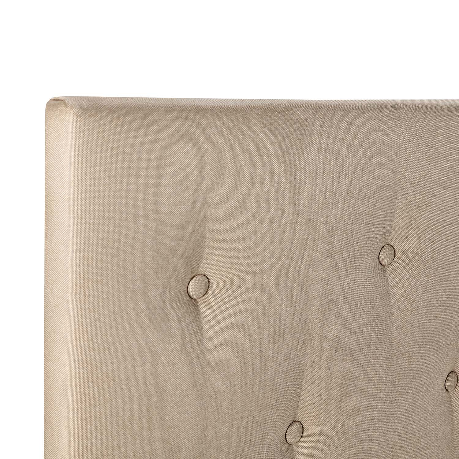 Primer plano de un cabecero tapizado beige con botones de capitoné visibles, sobre un fondo blanco.