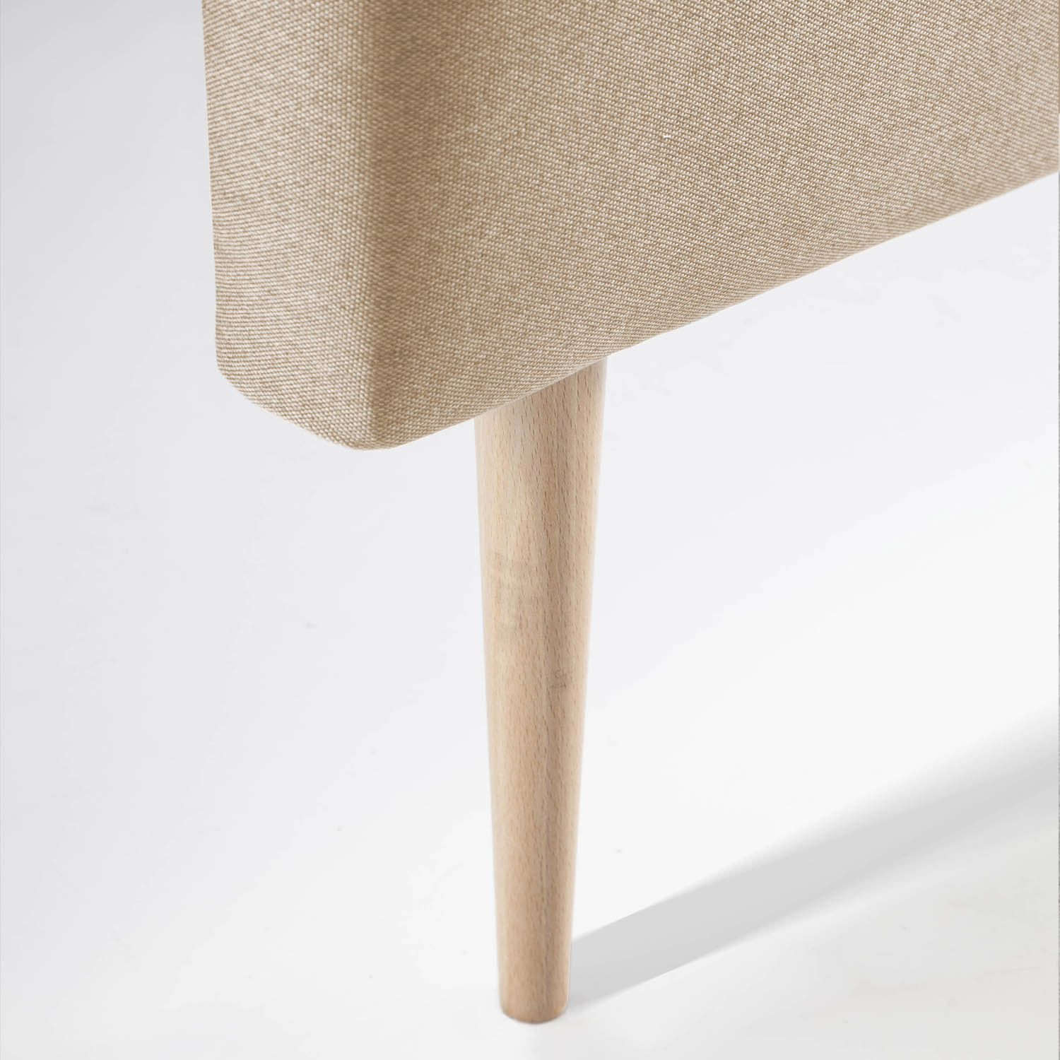 Una sola pata de madera soporta un taburete tapizado beige sobre fondo blanco.