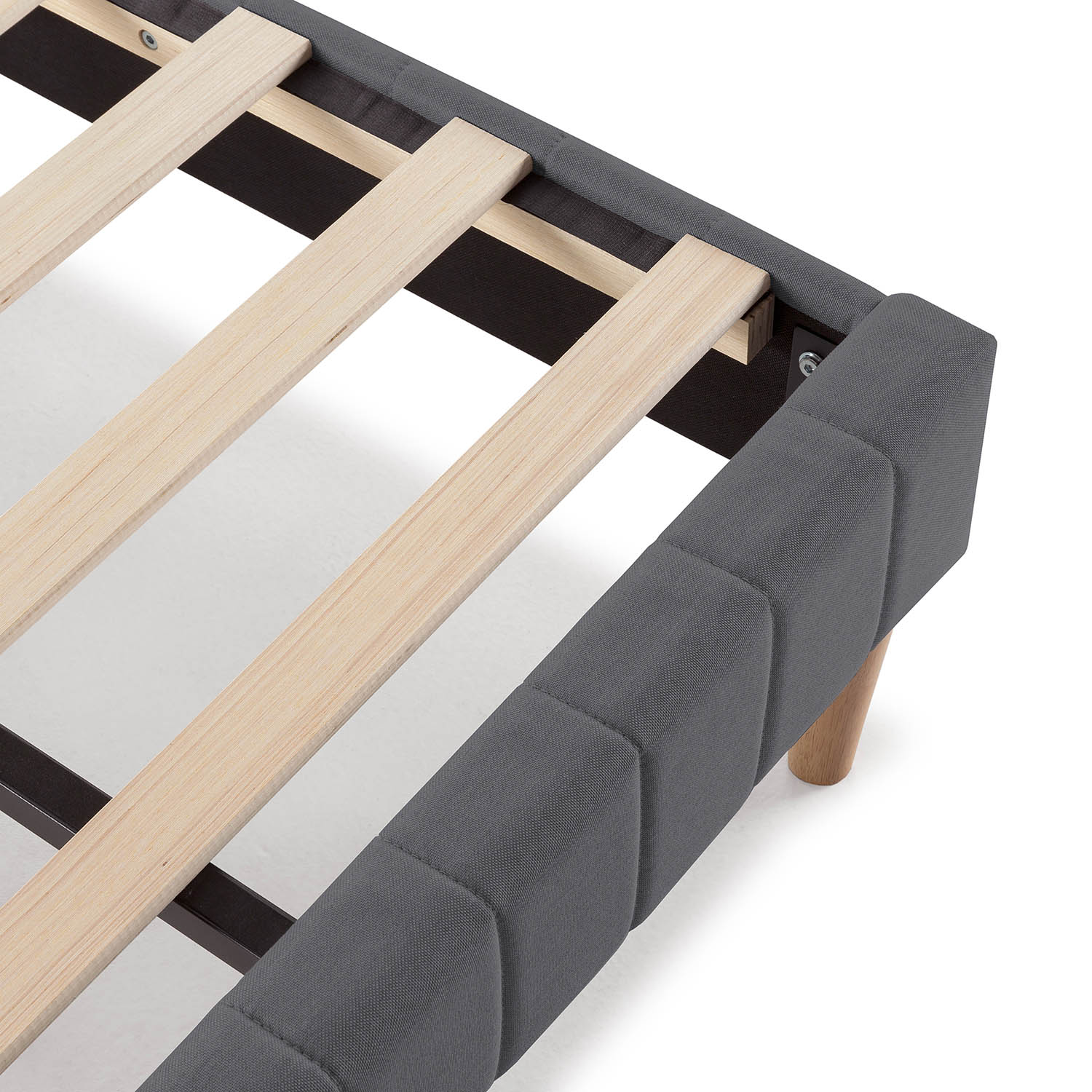 Primer plano de un somier tapizado gris con listones de madera.