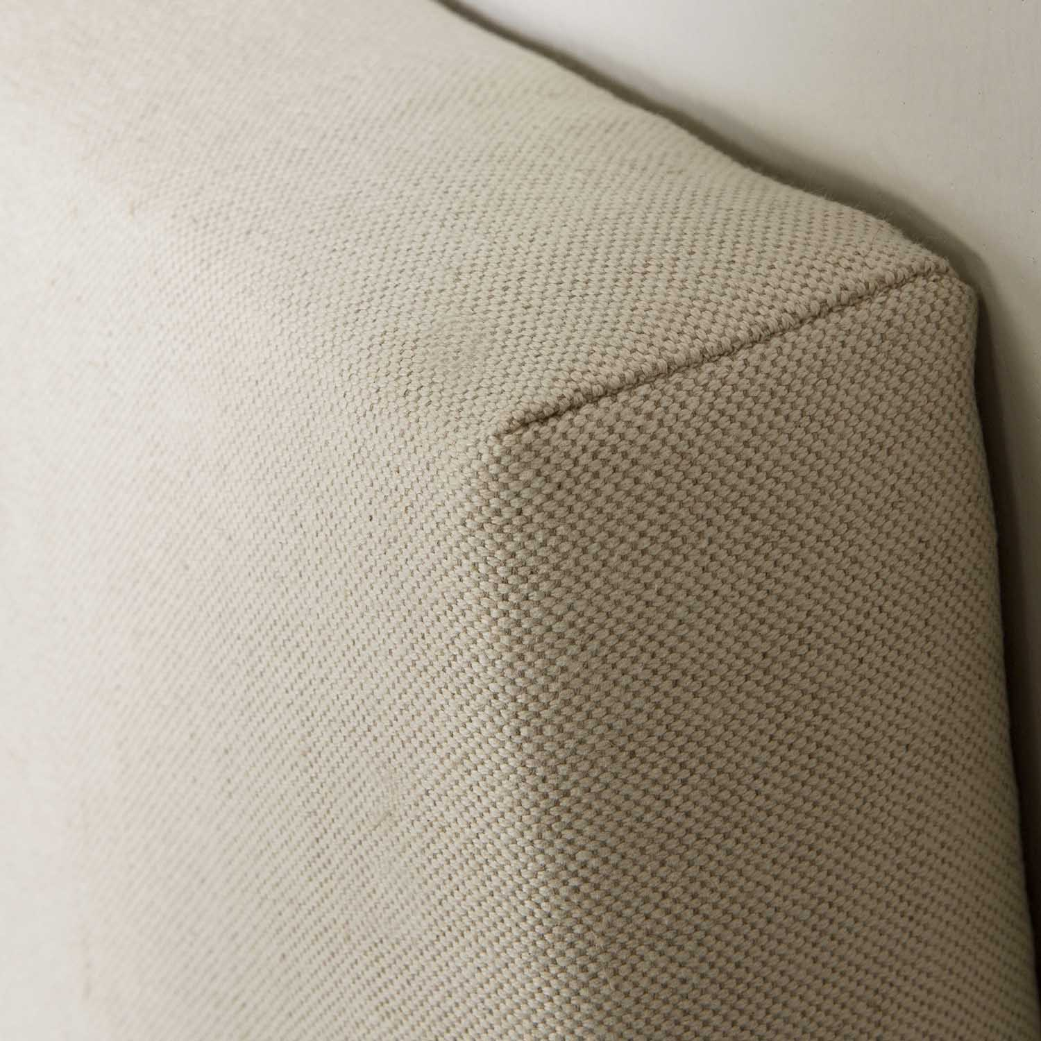Primer plano de tela beige con textura de tejido visible y una esquina.