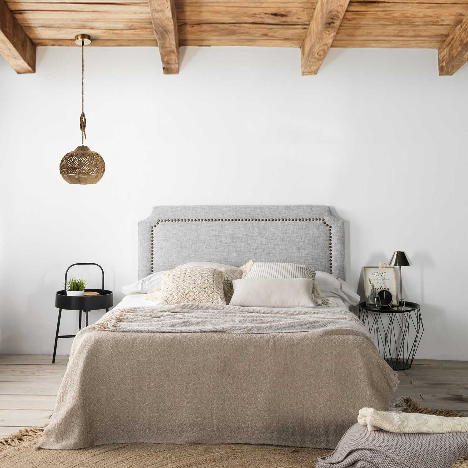 Un dormitorio acogedor con cama, mesitas de noche y vigas de madera en el techo.