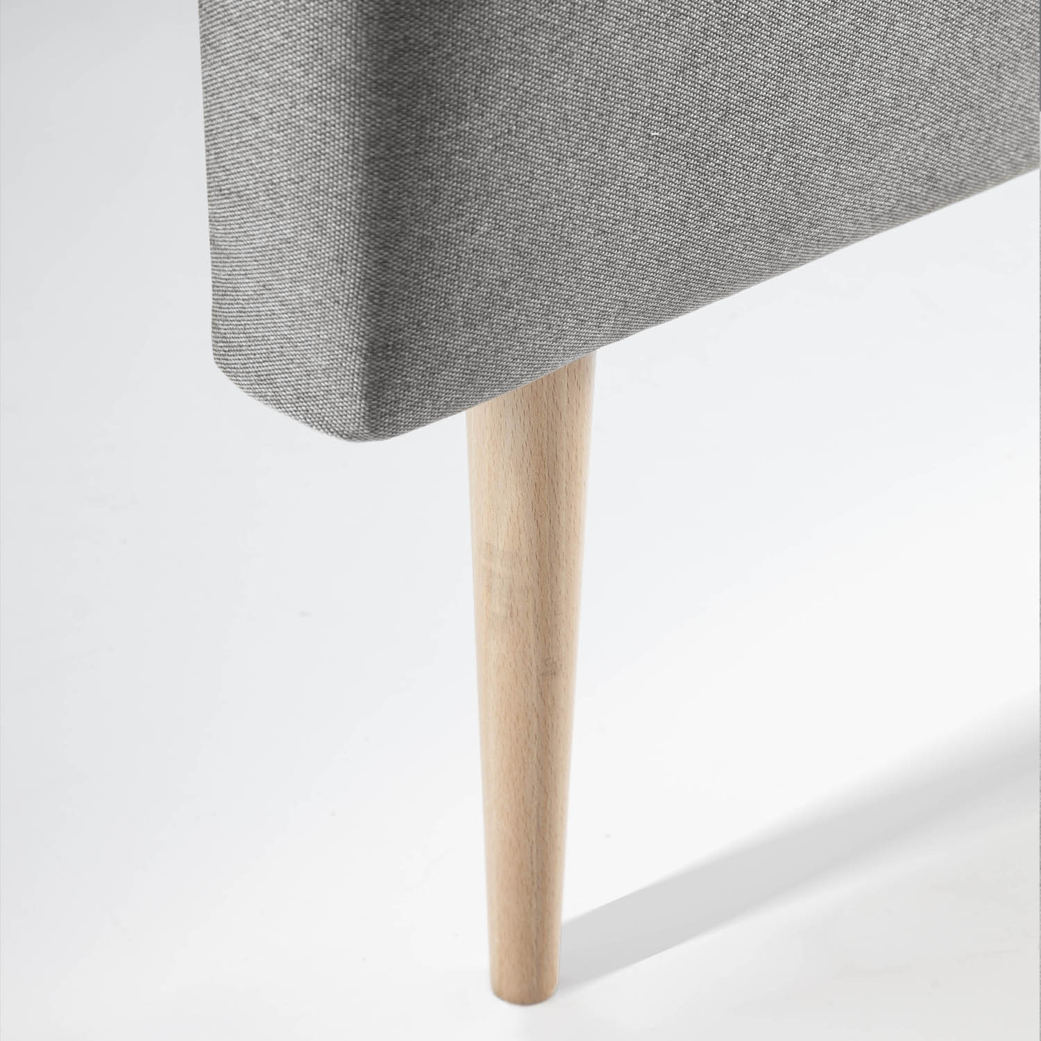 Una cubierta de tela gris con una pata de madera cónica sobre fondo blanco.