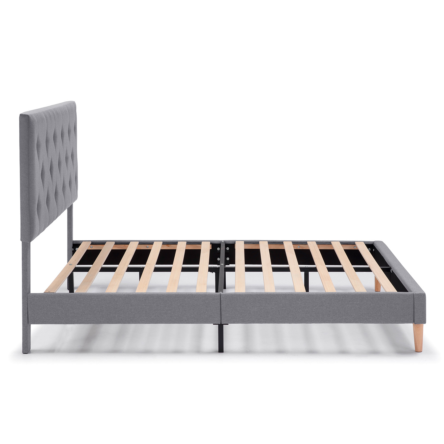 Un somier tapizado gris con cabecero capitoné y listones de madera.
