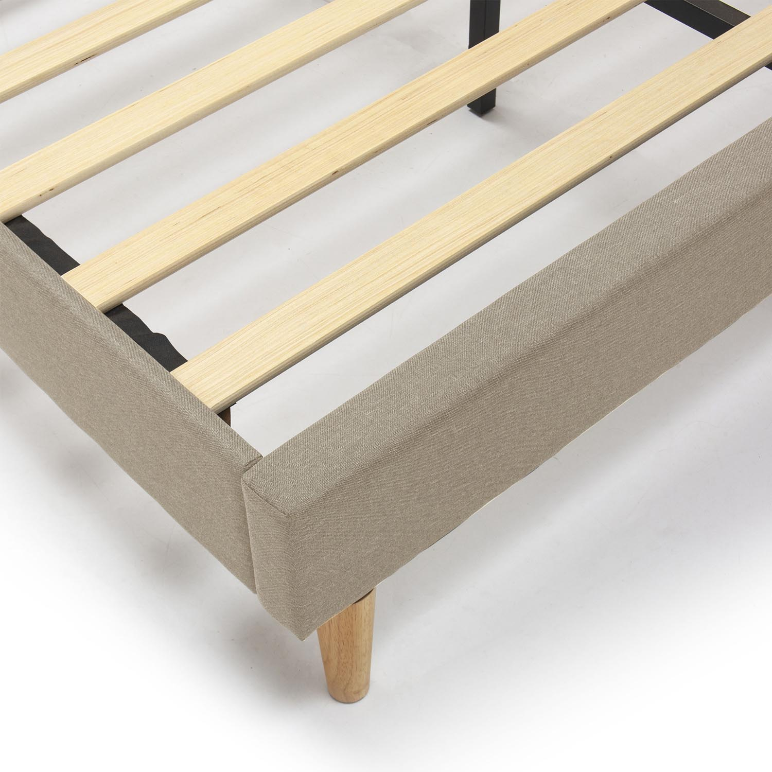 Primer plano de un somier con listones de madera y tapicería de tela beige.