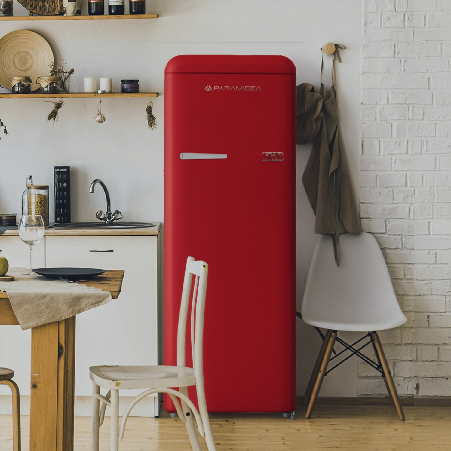 Un vivace frigorifero rosso si erge in una cucina, affiancato da scaffali in legno, un lavello e un tavolo da pranzo con sedie.