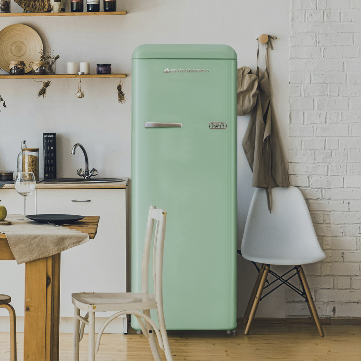 Un frigorifero verde menta in una cucina, accanto a un tavolo di legno e sedie.