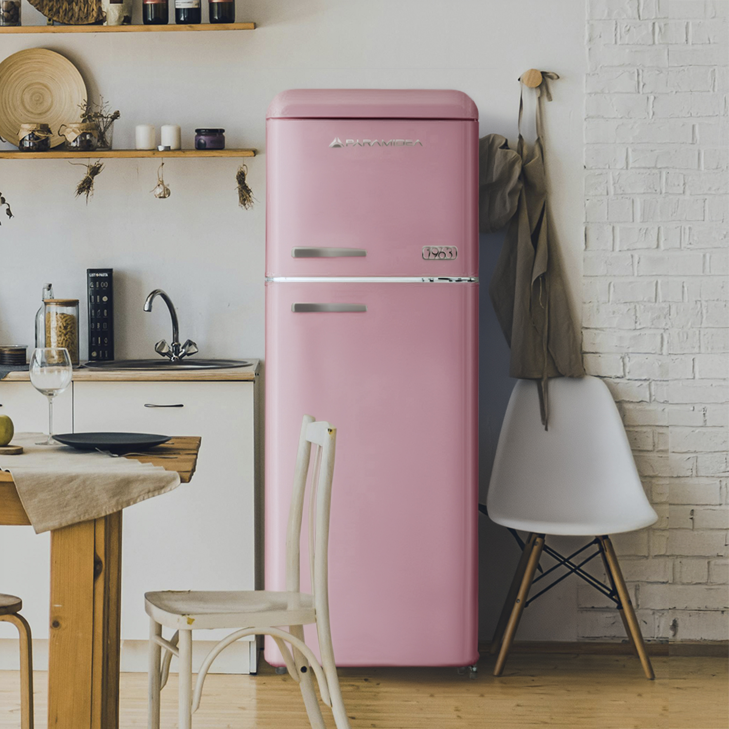 Una cucina retrò rosa con frigorifero, lavello, tavolo in legno e sedie.