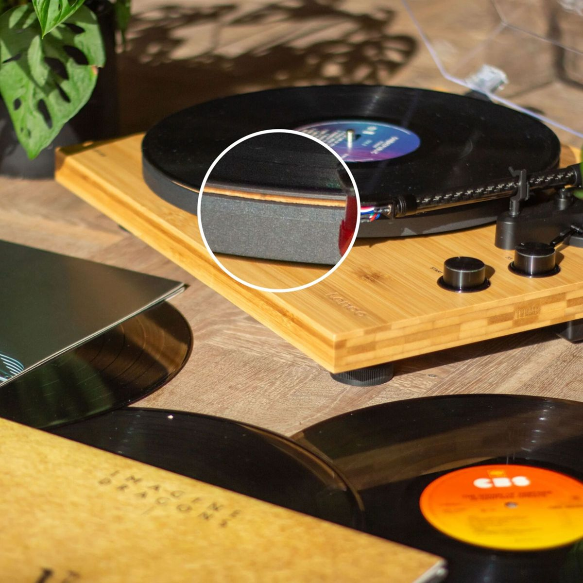 Een platenspeler met een plaat, omringd door andere platen.