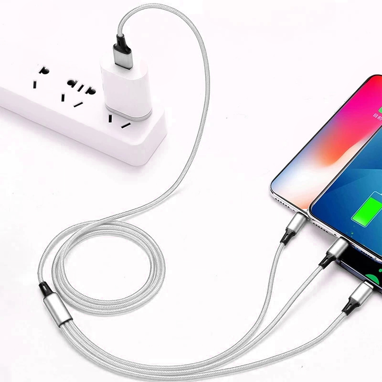 Beyaz bir güç adaptörü, iki telefonu şarj eden bir şarj kablosuna bağlı bir güç şeridine takılıdır.