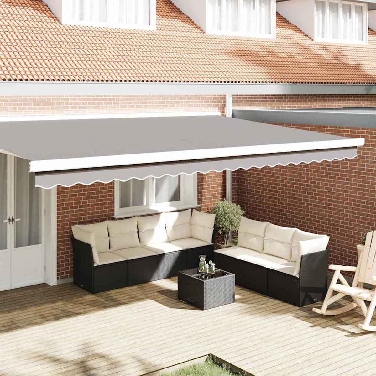 Markisen bedecken eine Terrasse mit Korbmöbeln, einem Couchtisch und einem Schaukelstuhl.