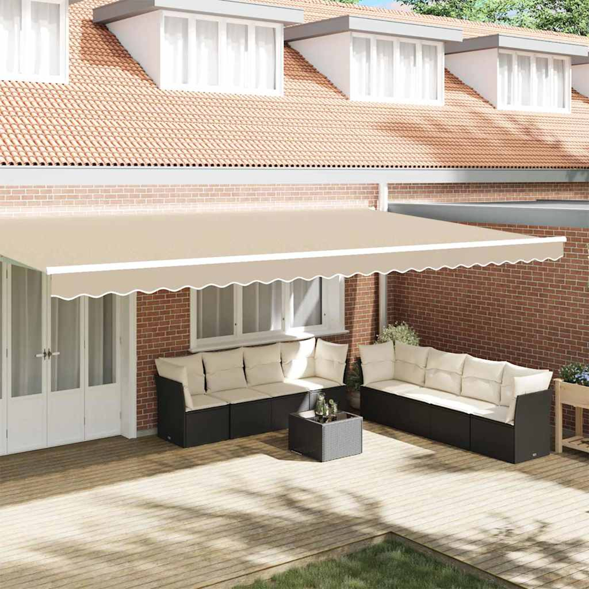 Eine beige Markise über einem Gartenmöbel-Set aus dunklen Sofas mit weißen Kissen und einem Tisch.