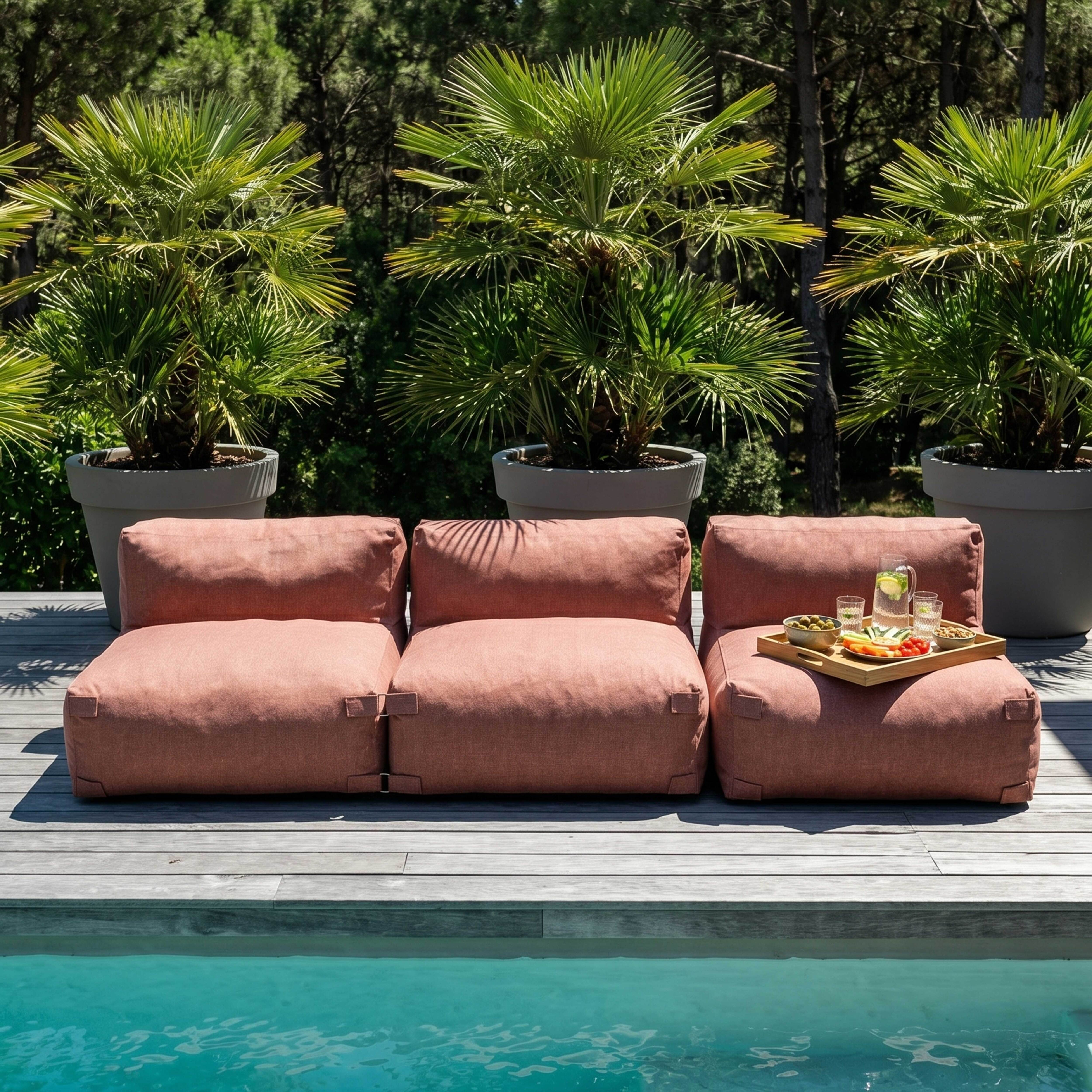 Ein rosafarbener Lounge-Sessel am Pool mit einem Tablett voller Snacks und Getränke.