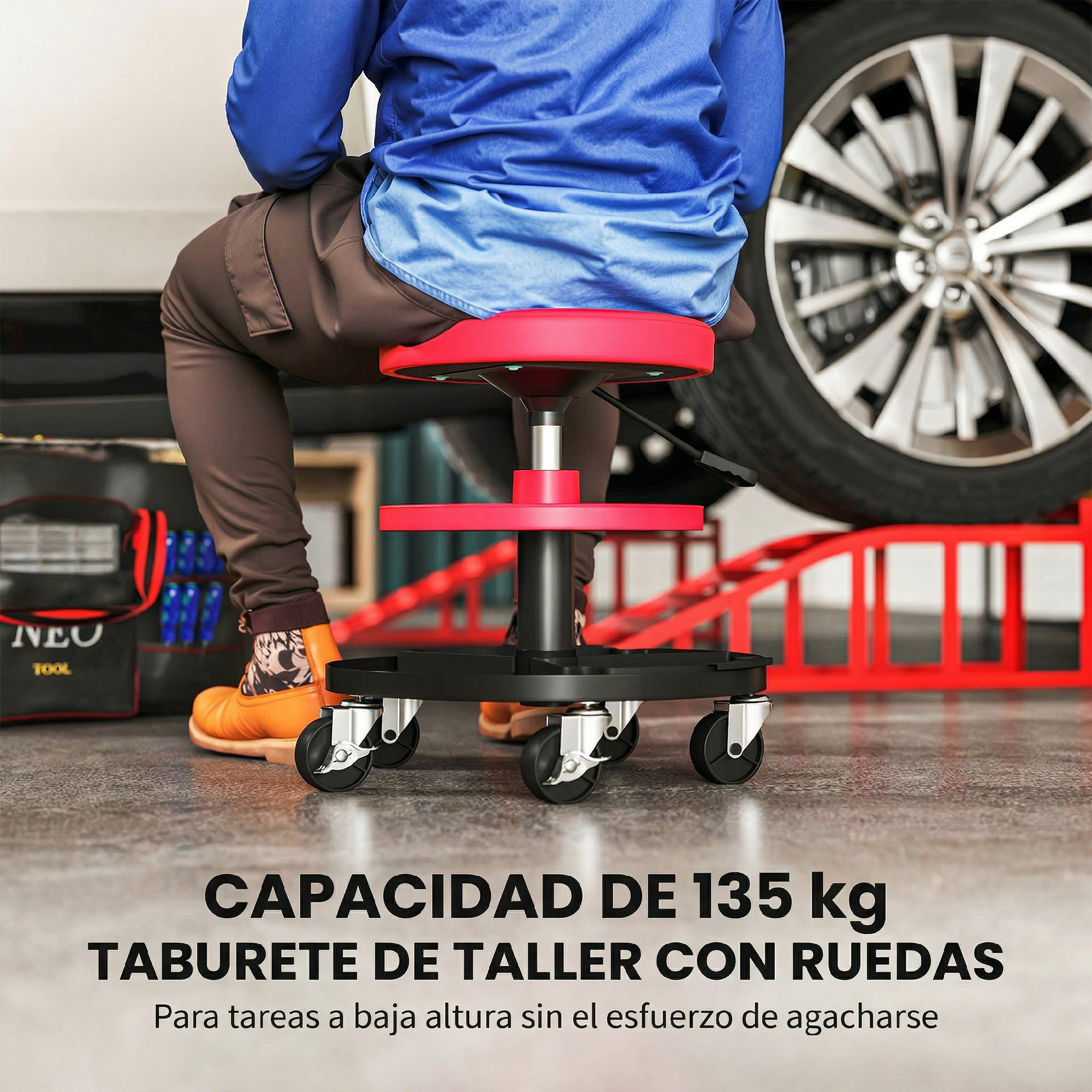 Persona sentada en un taburete rojo de taller con ruedas, frente a una rueda de coche.