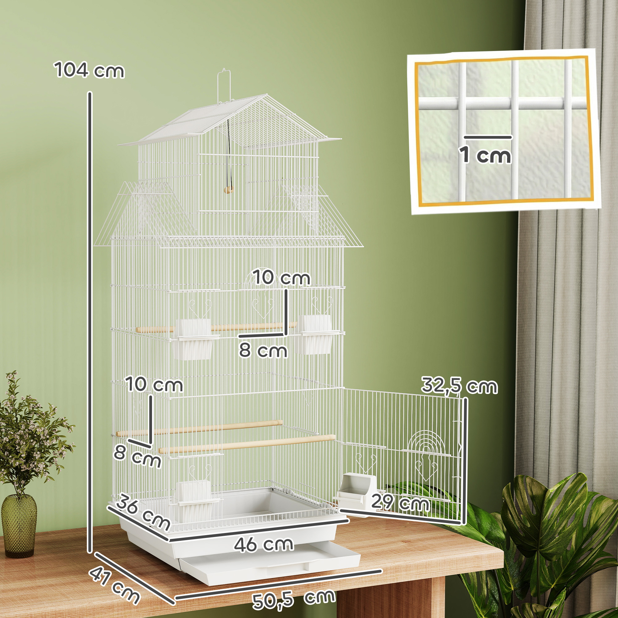 Una jaula blanca para pájaros con accesorios sobre una mesa de madera. Se muestran las dimensiones.
