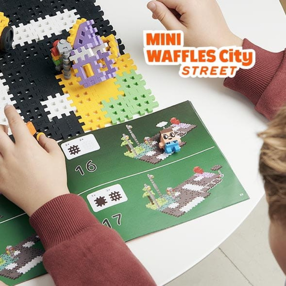 Dzieci budują z kolorowych klocków waflowych według instrukcji.
