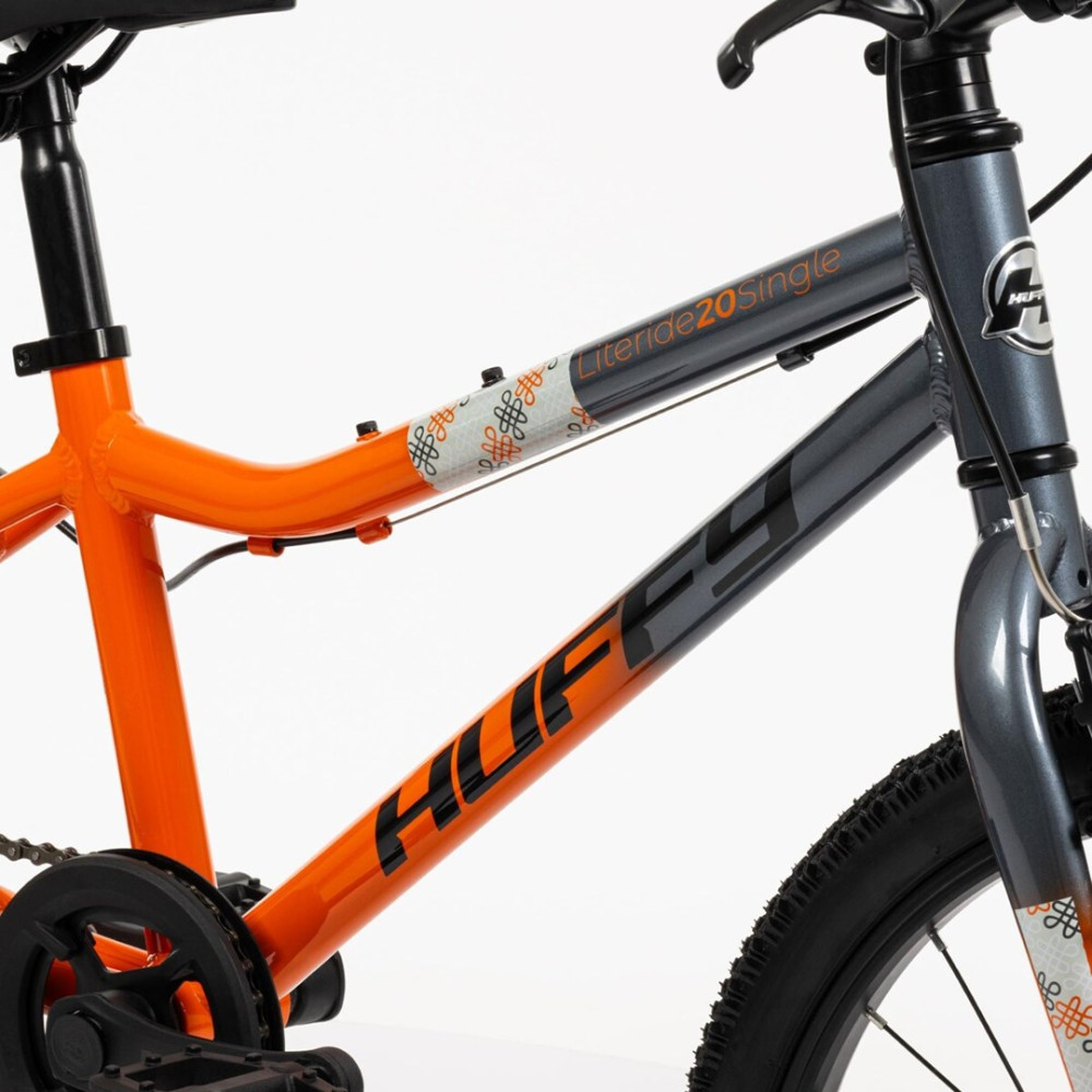 Nahaufnahme eines grauen und orangen Huffy-Fahrrads. Der Rahmen hat Text 'HUFFY' und 'Literide20Single'.