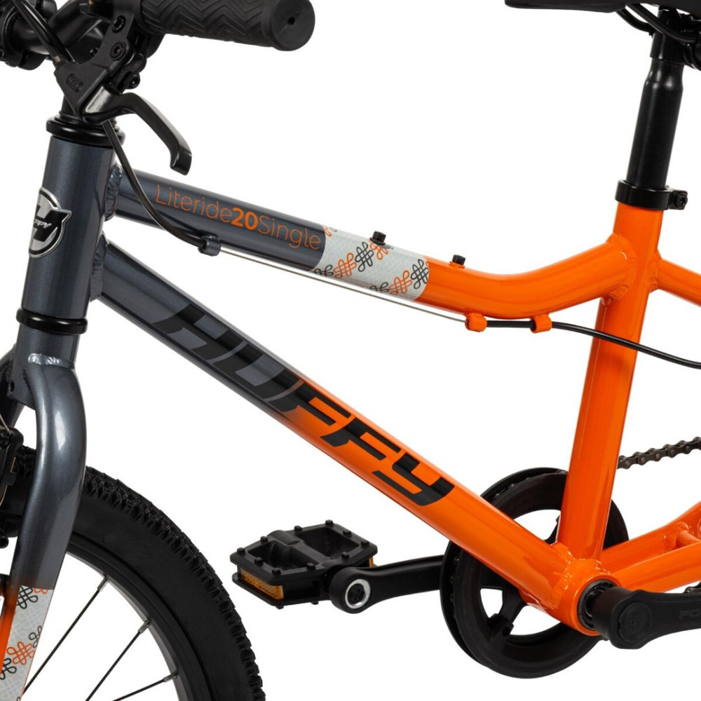 Ein grauer und oranger Huffy Kinderfahrradrahmen mit Pedalen und Kette.