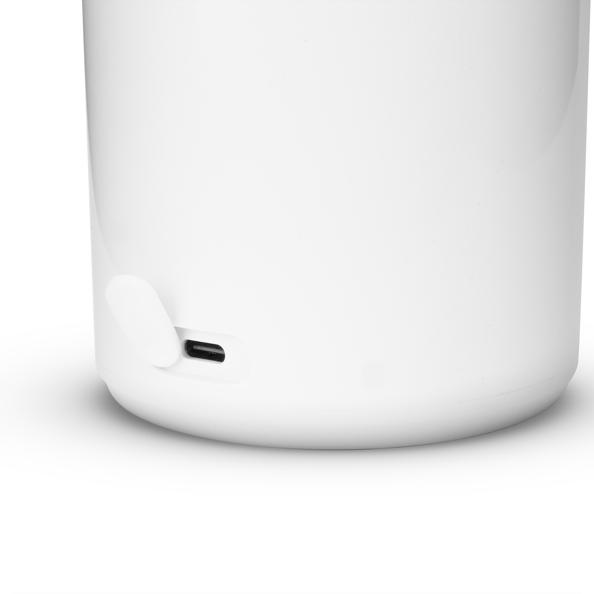 Zbliżenie białego cylindra z portem USB i klapką.
