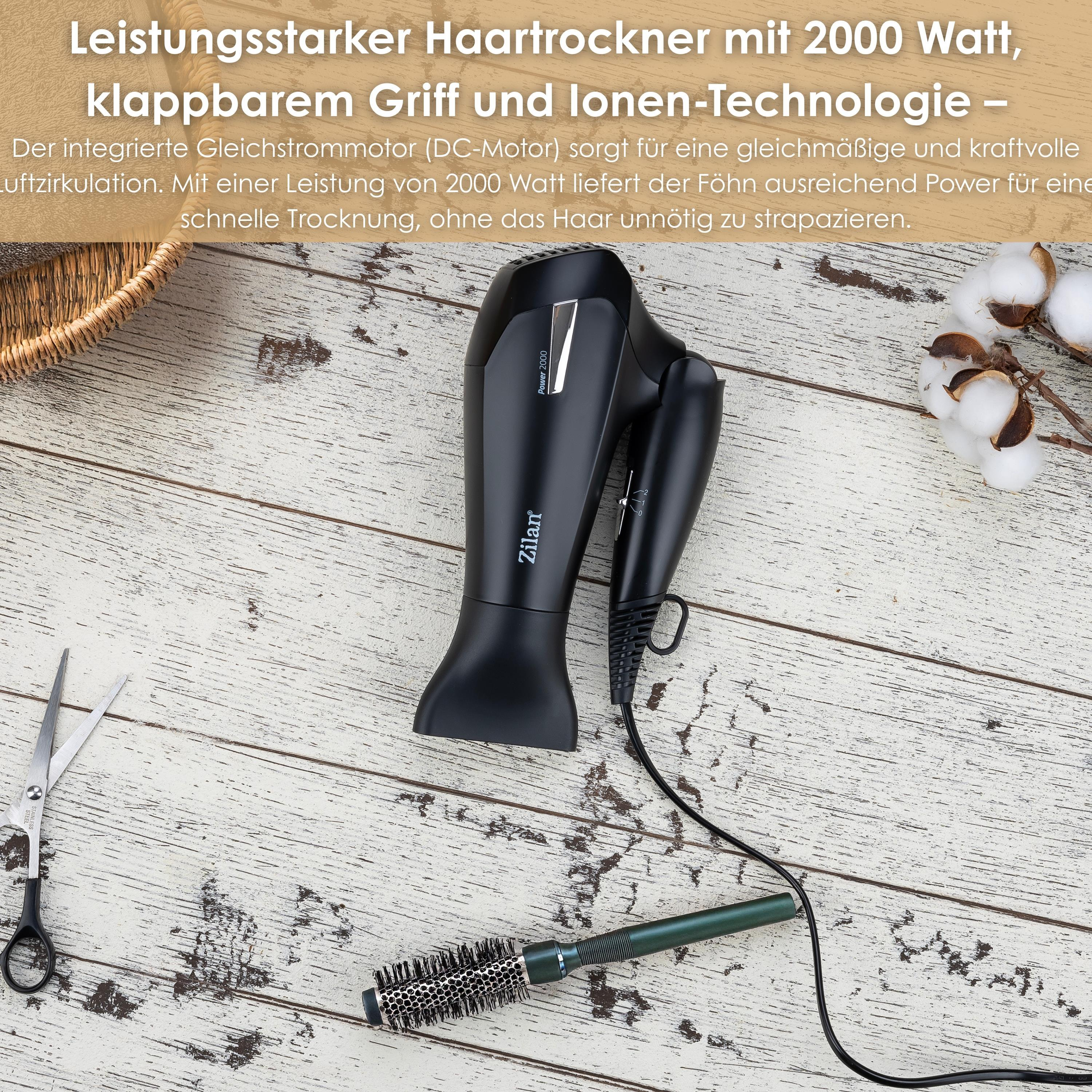 Ein schwarzer Haartrockner liegt auf einer Holzlackoberfläche neben einer Bürste und Schere.