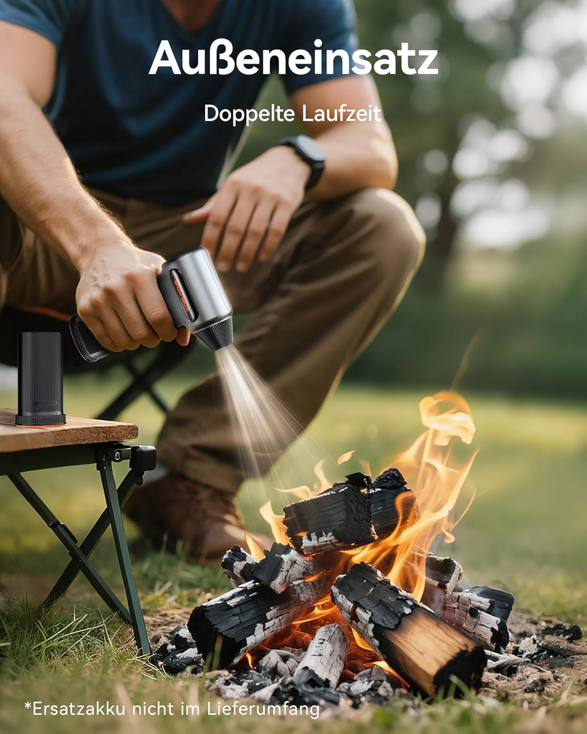 Mann benutzt Gebläse für Lagerfeuer auf einem Campingausflug.