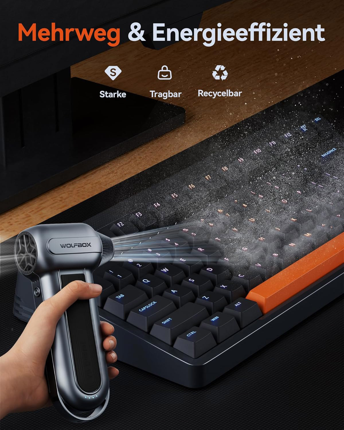 Eine Hand hält einen grauen kabellosen Bläser, der auf eine Tastatur gerichtet ist.