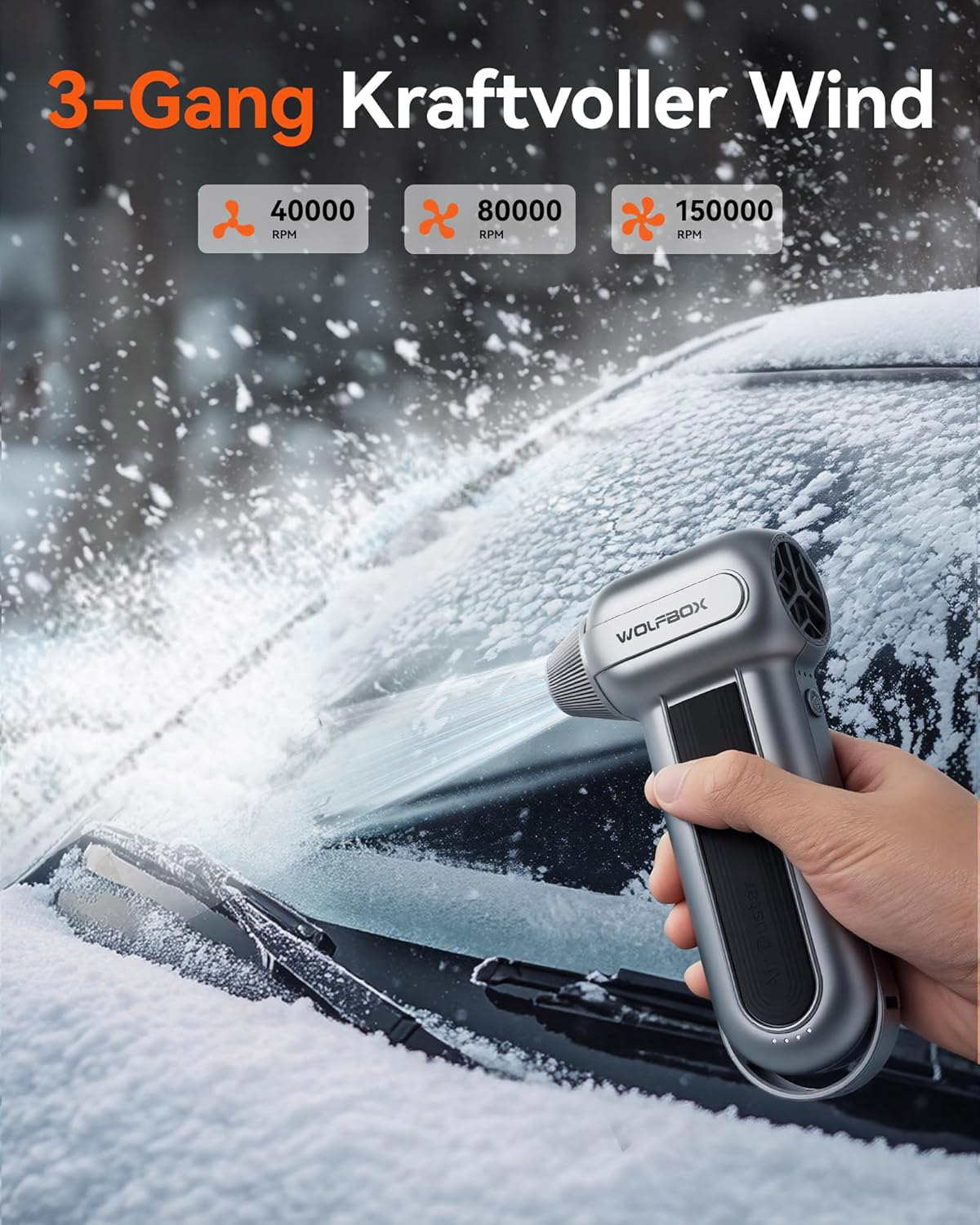 Ein silberner WOLFBOX Air Duster reinigt ein verschneites Auto-Windschutzscheibe.