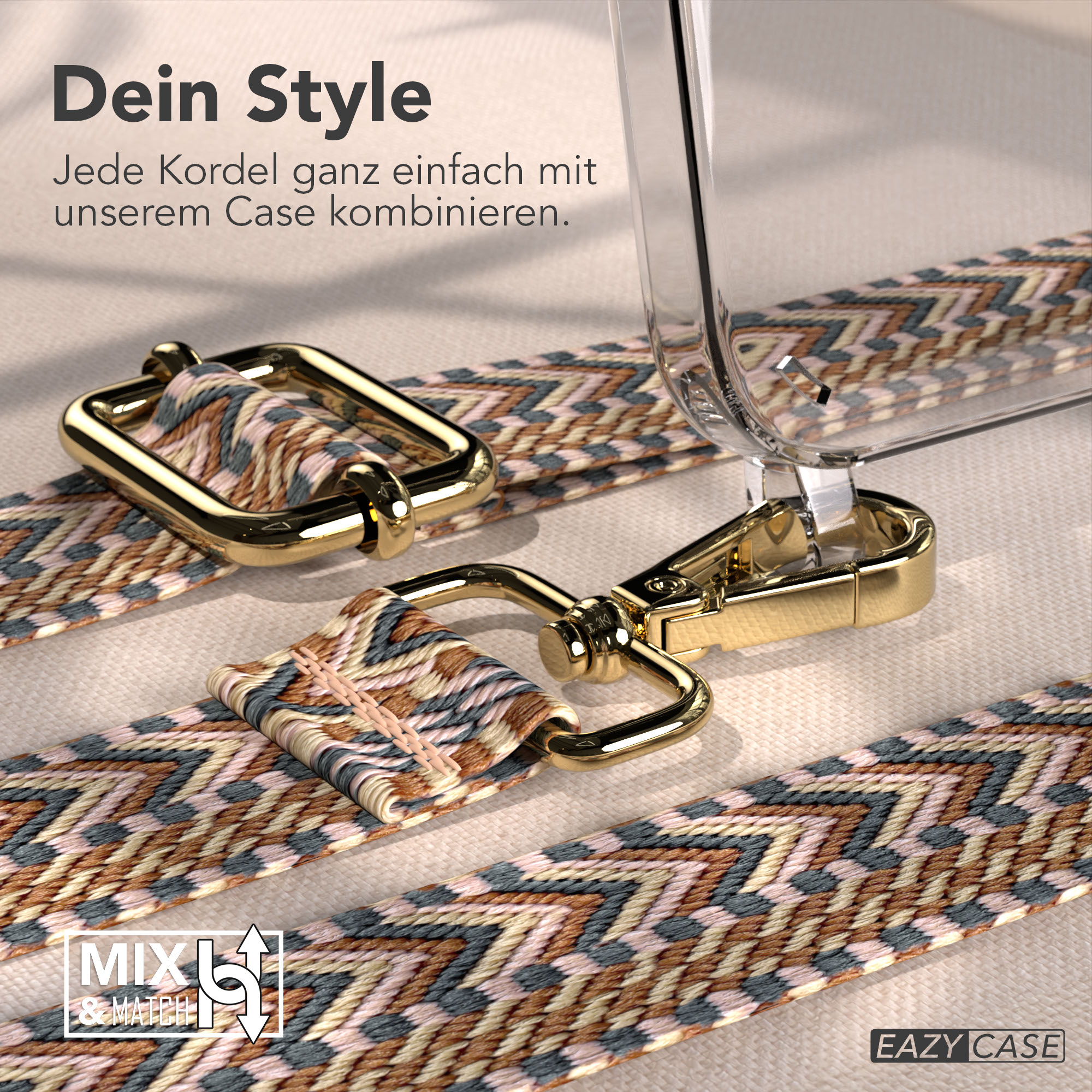 Ein Handy-Lanyard mit Muster und goldenen Clips liegt auf einem Stoff.