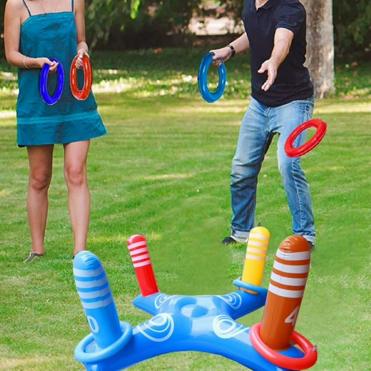 Leute spielen Ringewerfen auf einer Rasenfläche mit aufblasbarem Ziel.