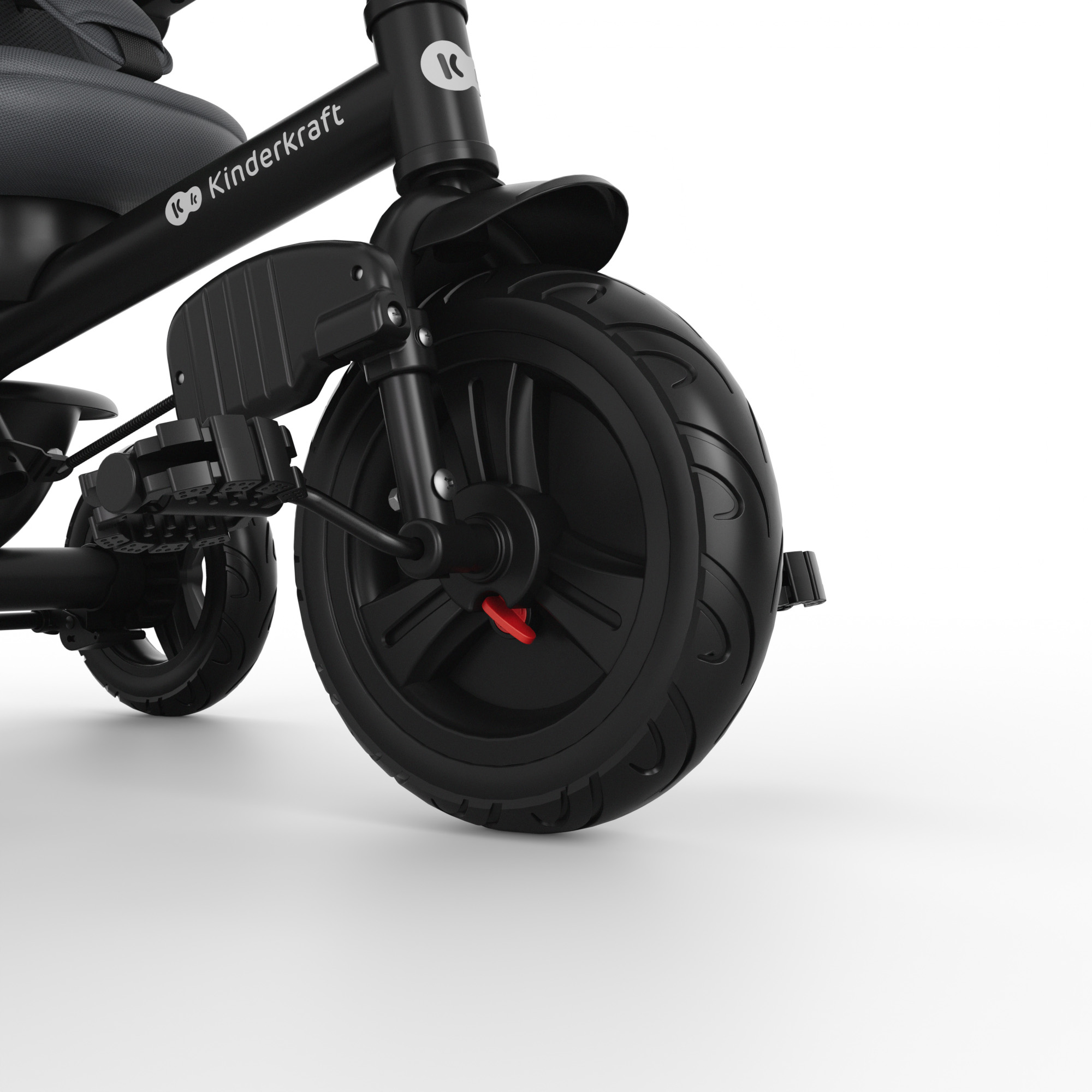 Primer plano de un triciclo negro con asiento infantil y logo.