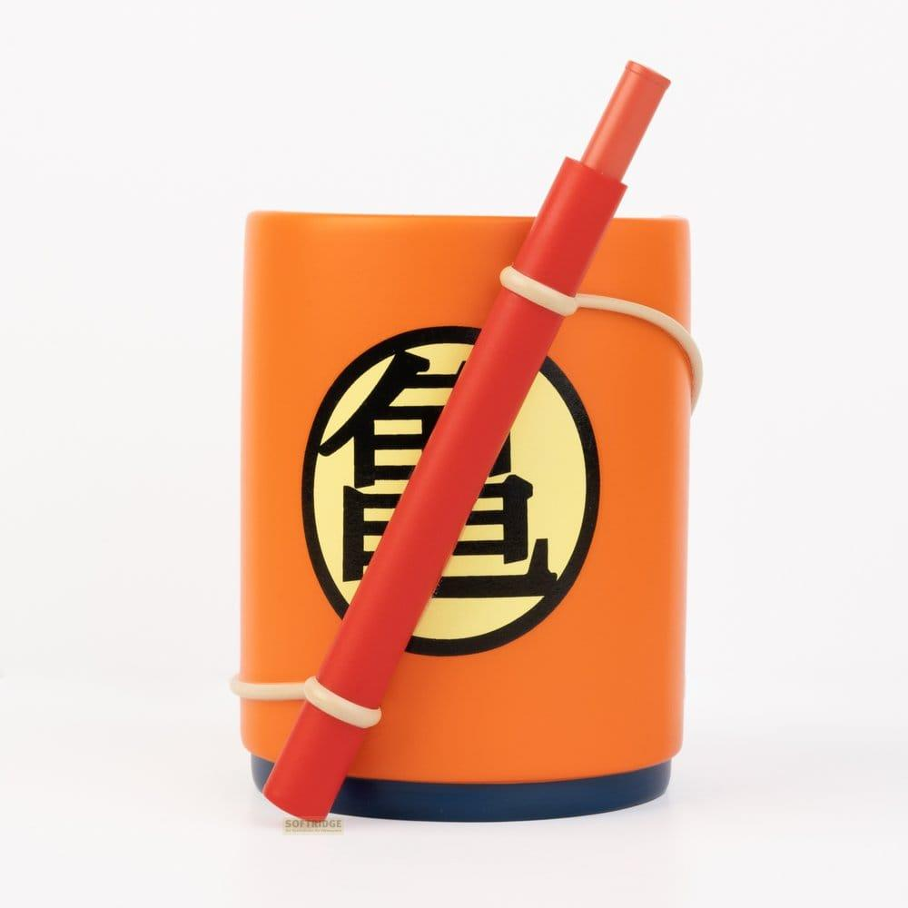 Orangefarbener Becher mit Drachenball-Symbol und rotem Stab, der mit Gummibändern befestigt ist.