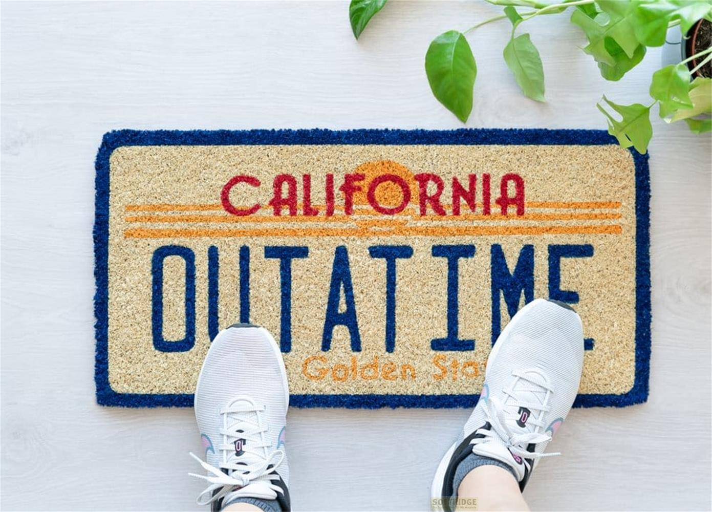 Felpudo con la inscripción 'CALIFORNIA OUT AT TIME' y borde azul.