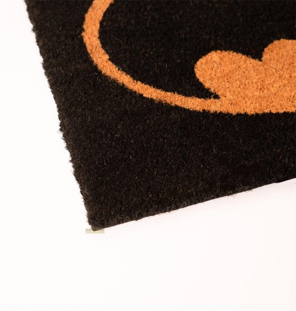 Ein schwarzer Teppich mit dem orangefarbenen Batman-Logo.