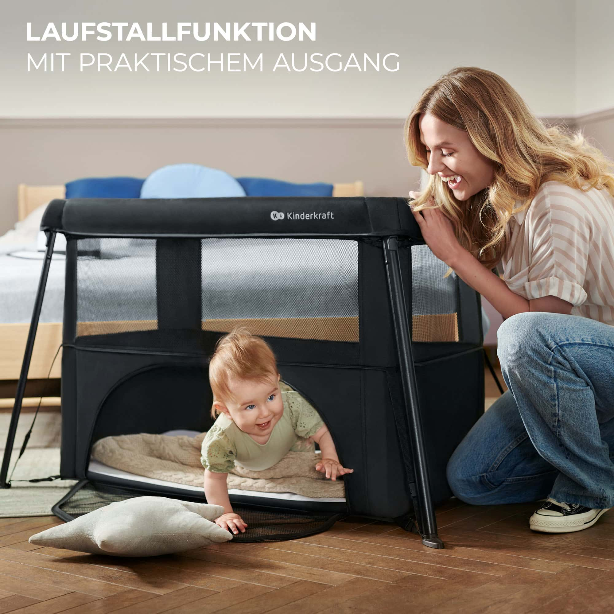Eine Frau lächelt ein Baby an, das aus einem schwarzen Laufstall mit Netzseite krabbelt.