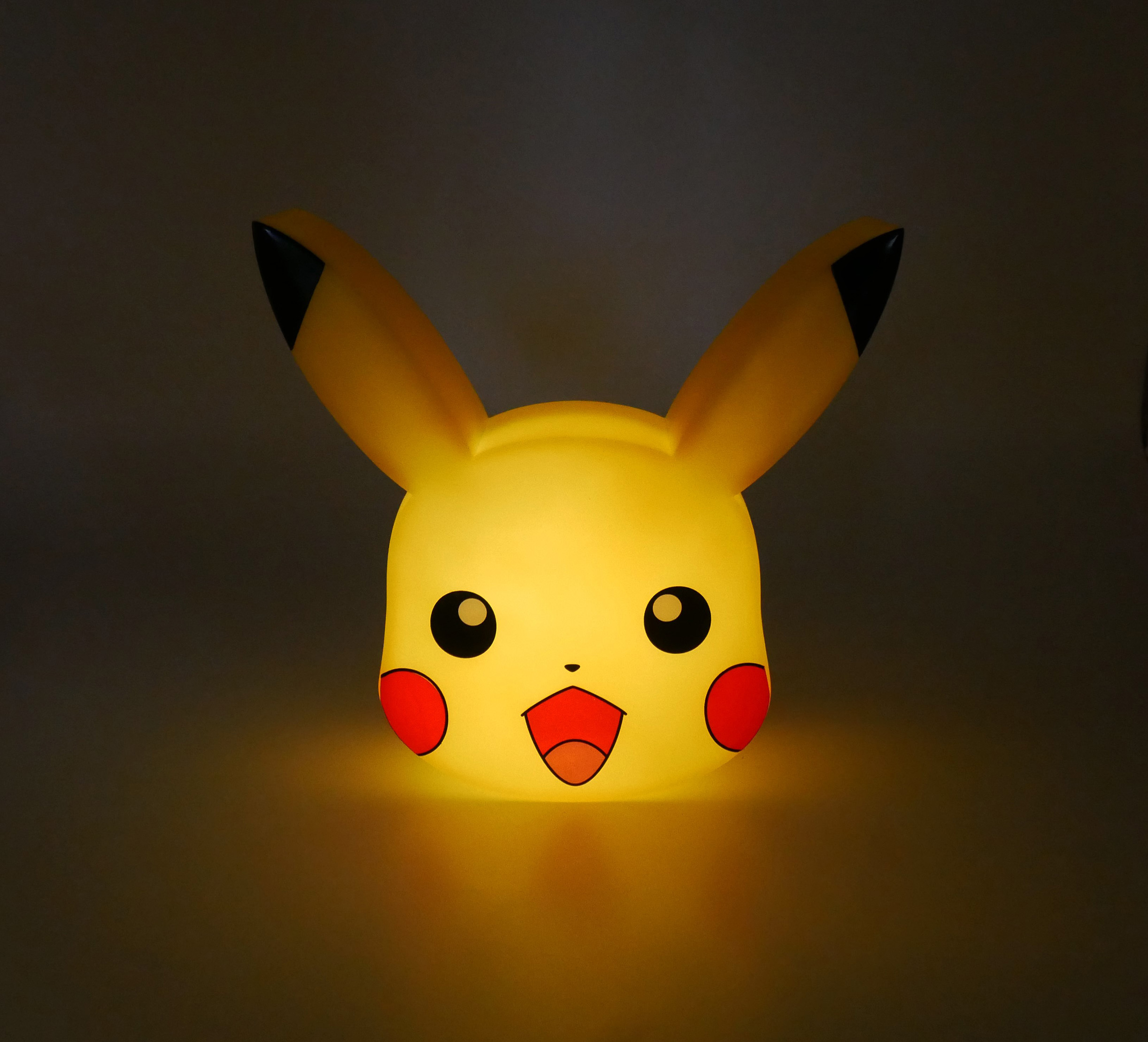 Eine leuchtende Pikachu-Lampe mit großen schwarzen Augen und roten Wangen.